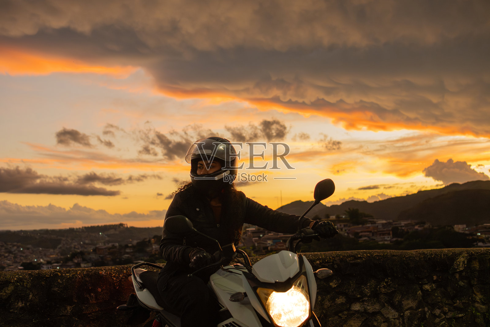 黄昏时分骑摩托车的女性旅行者照片摄影图片