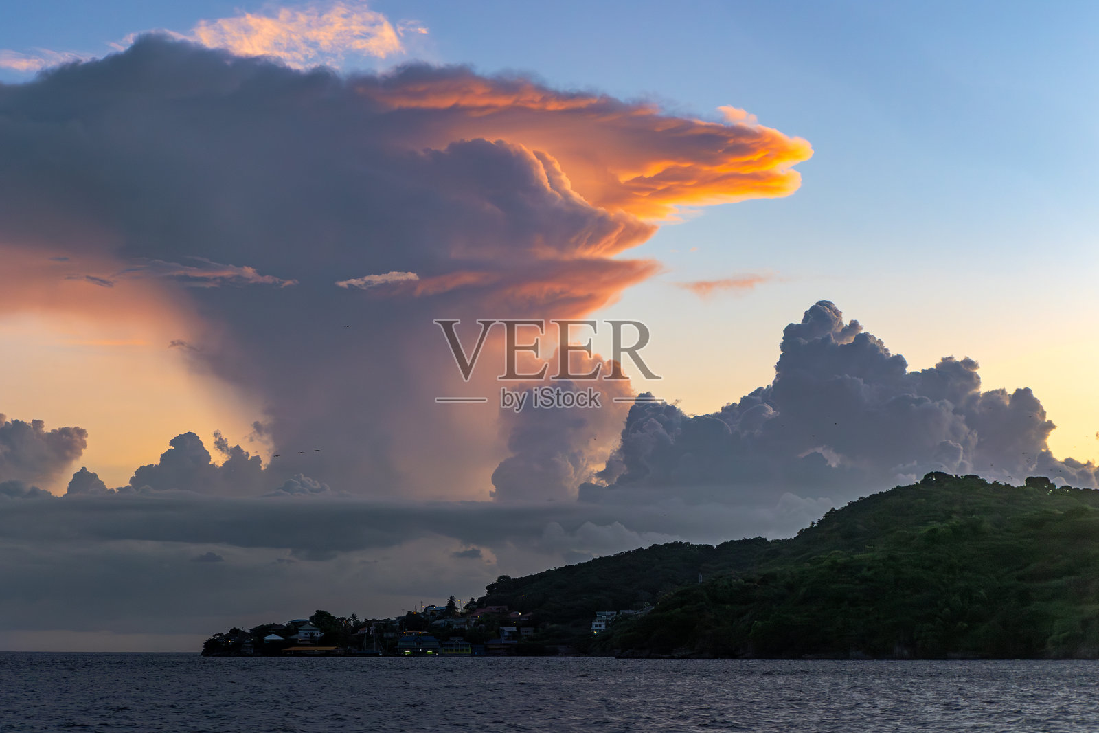 日落时分，特立尼达海岸上空的高耸积雨云照片摄影图片