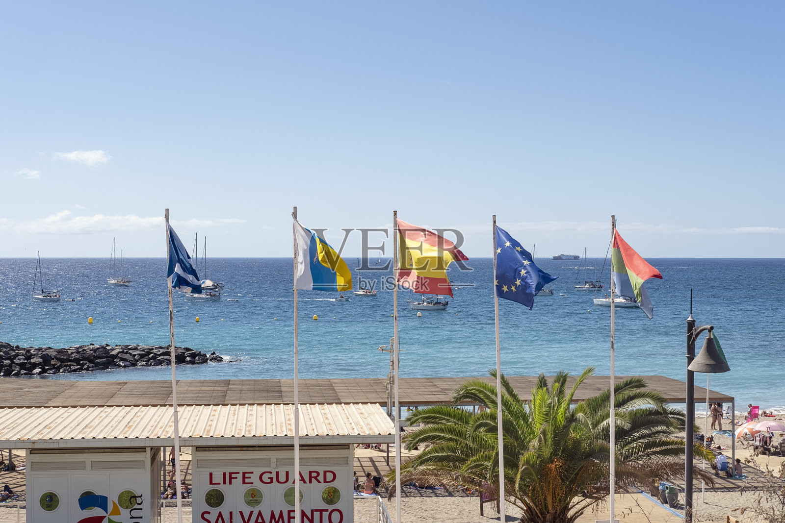 旗帜展示，第一面是特内里费岛的旗帜，第二面是加那利群岛的旗帜，第三面是西班牙的旗帜，第四面是欧盟的旗帜，最后一面是阿罗纳市的旗帜。照片摄影图片