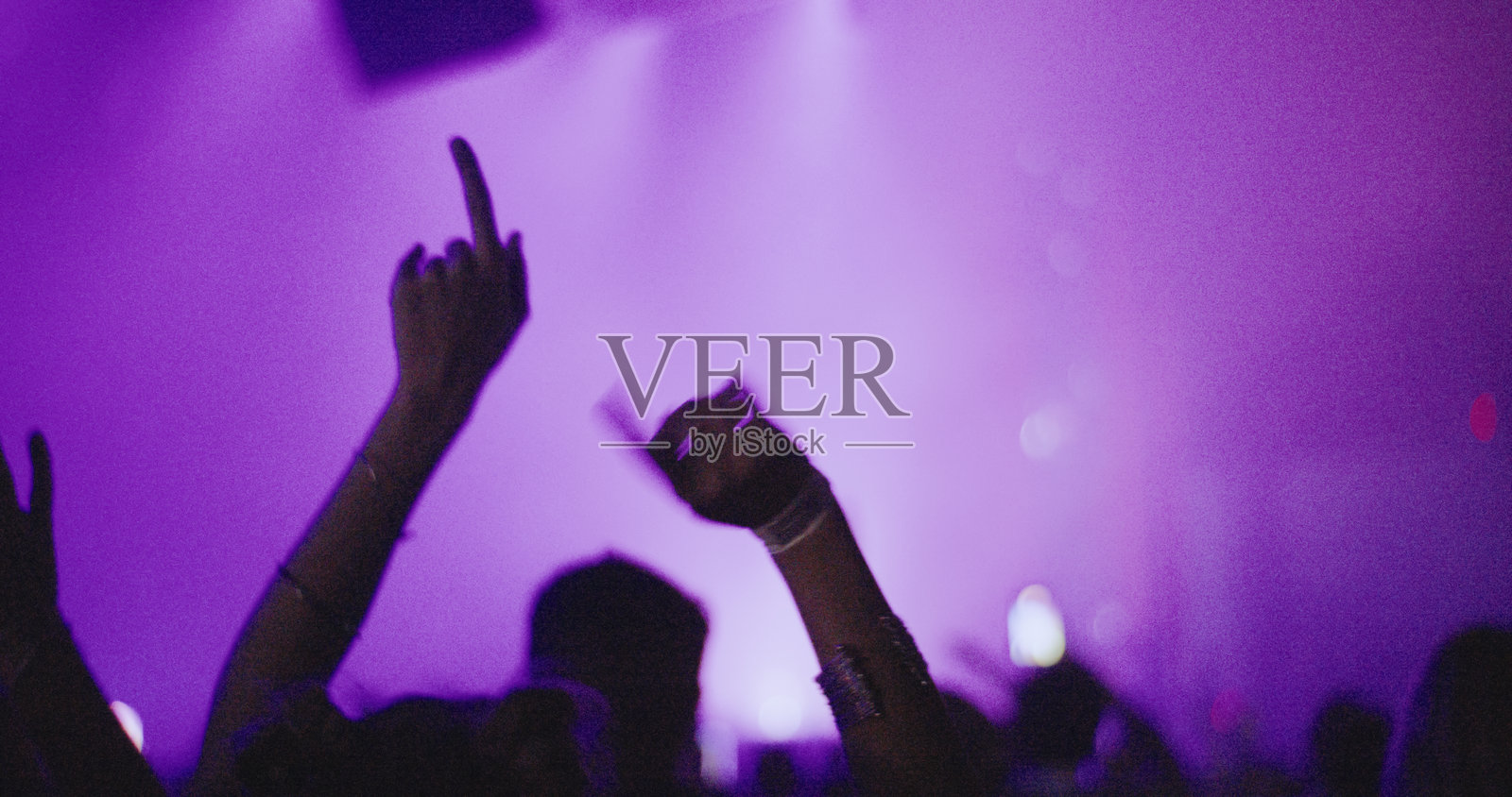 在音乐节上，剪影手势与照亮的舞台相映成趣照片摄影图片