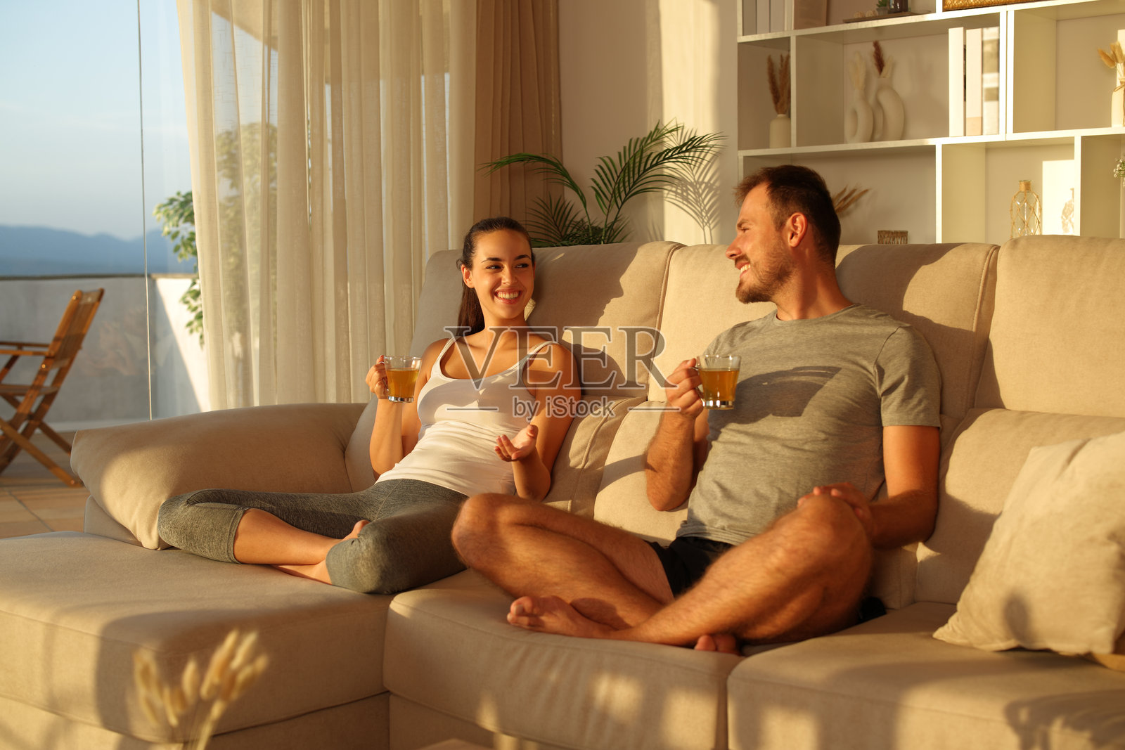 一对情侣在家做完瑜伽后喝茶聊天照片摄影图片