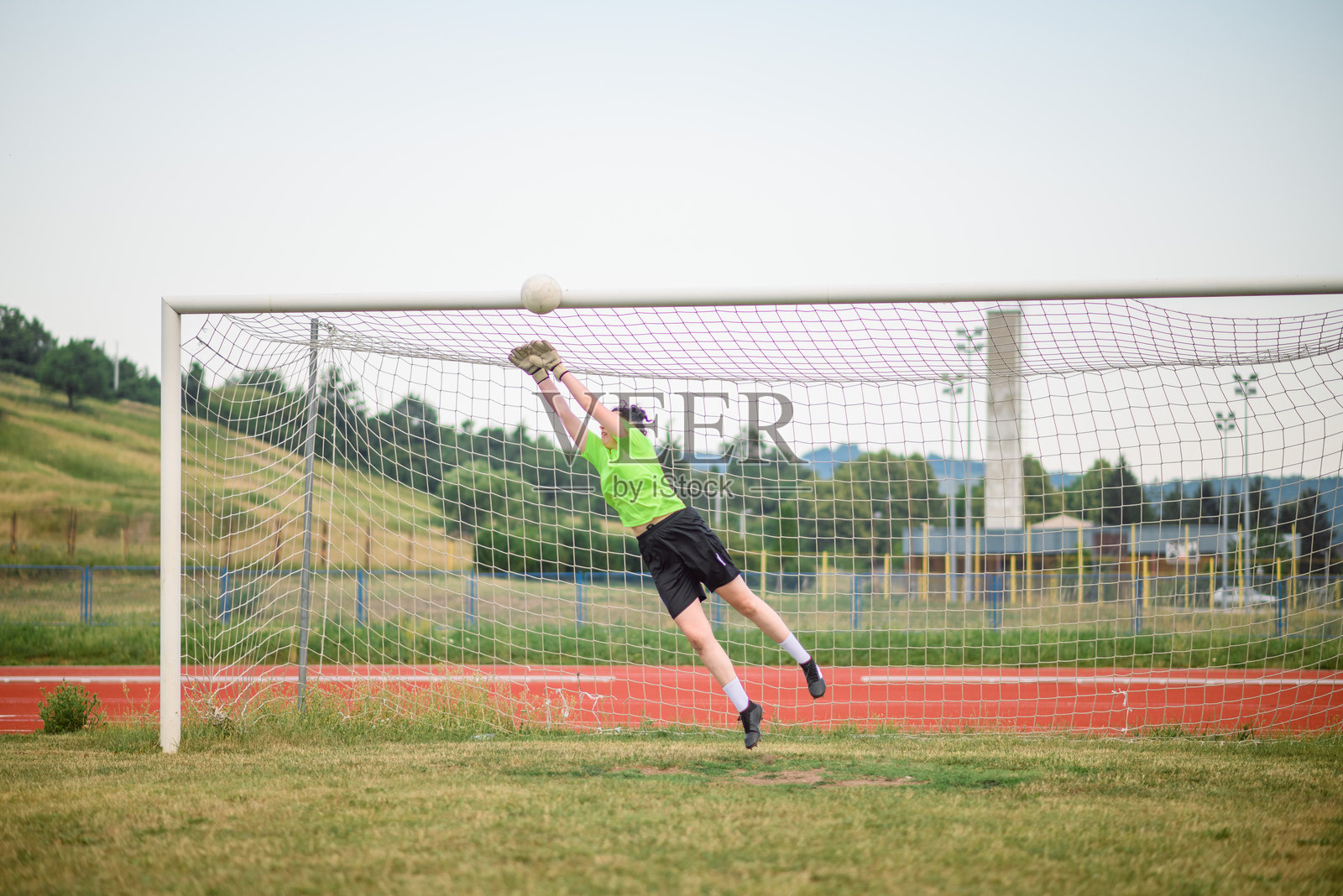 女守门员在比赛中扑救足球照片摄影图片