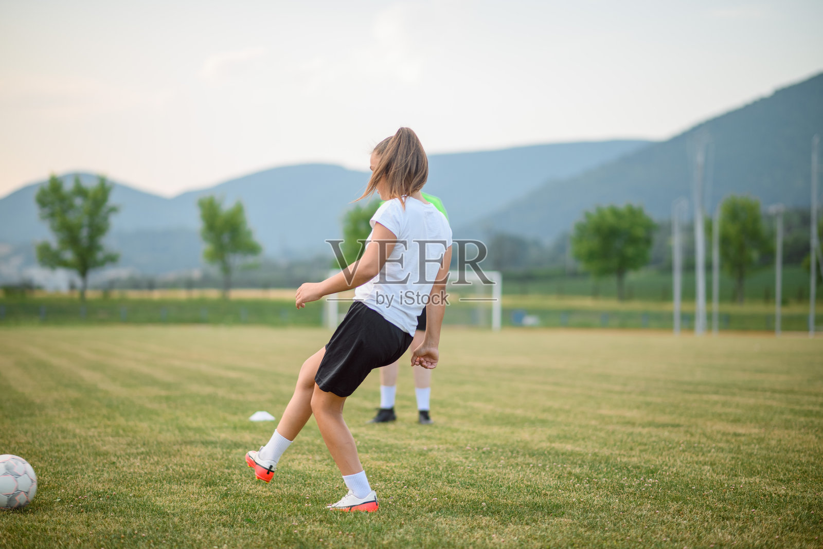 女足球运动员在场地上练习踢球照片摄影图片