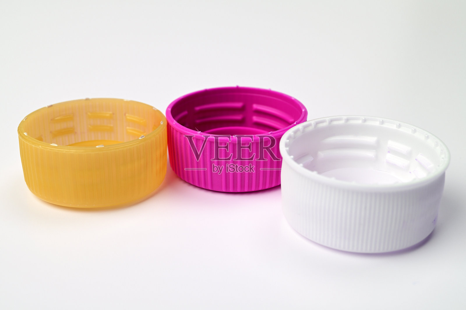 三个塑料瓶盖排成一行03照片摄影图片