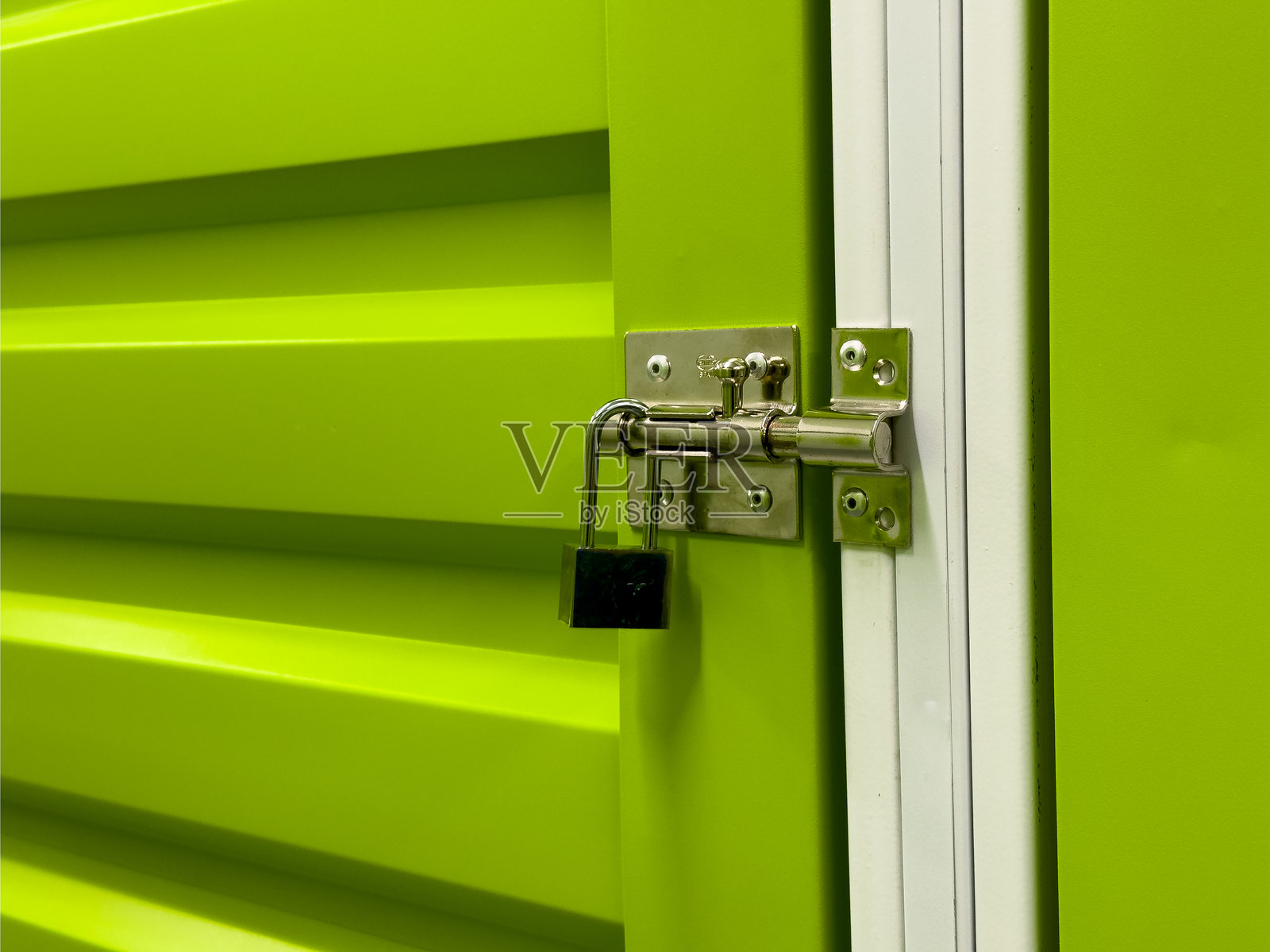 绿色金属储物门，配有挂锁和螺栓闩锁照片摄影图片
