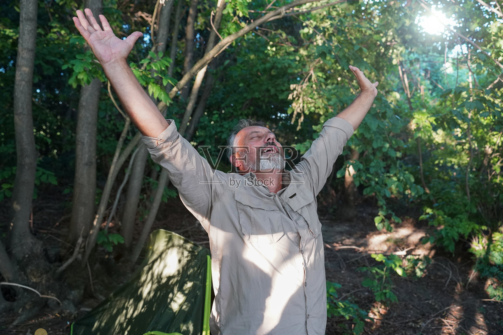 老年人在森林露营地伸展身体并醒来照片摄影图片