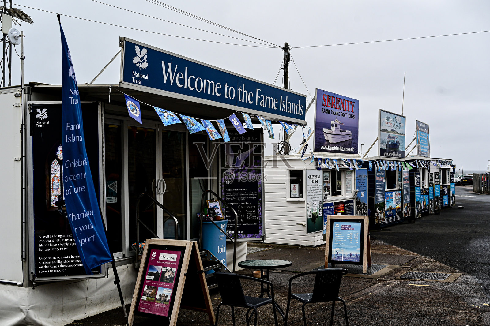 一排售货亭，游客可以在这里预订从英格兰诺森伯兰的西豪斯港出发的导游船之旅。照片摄影图片