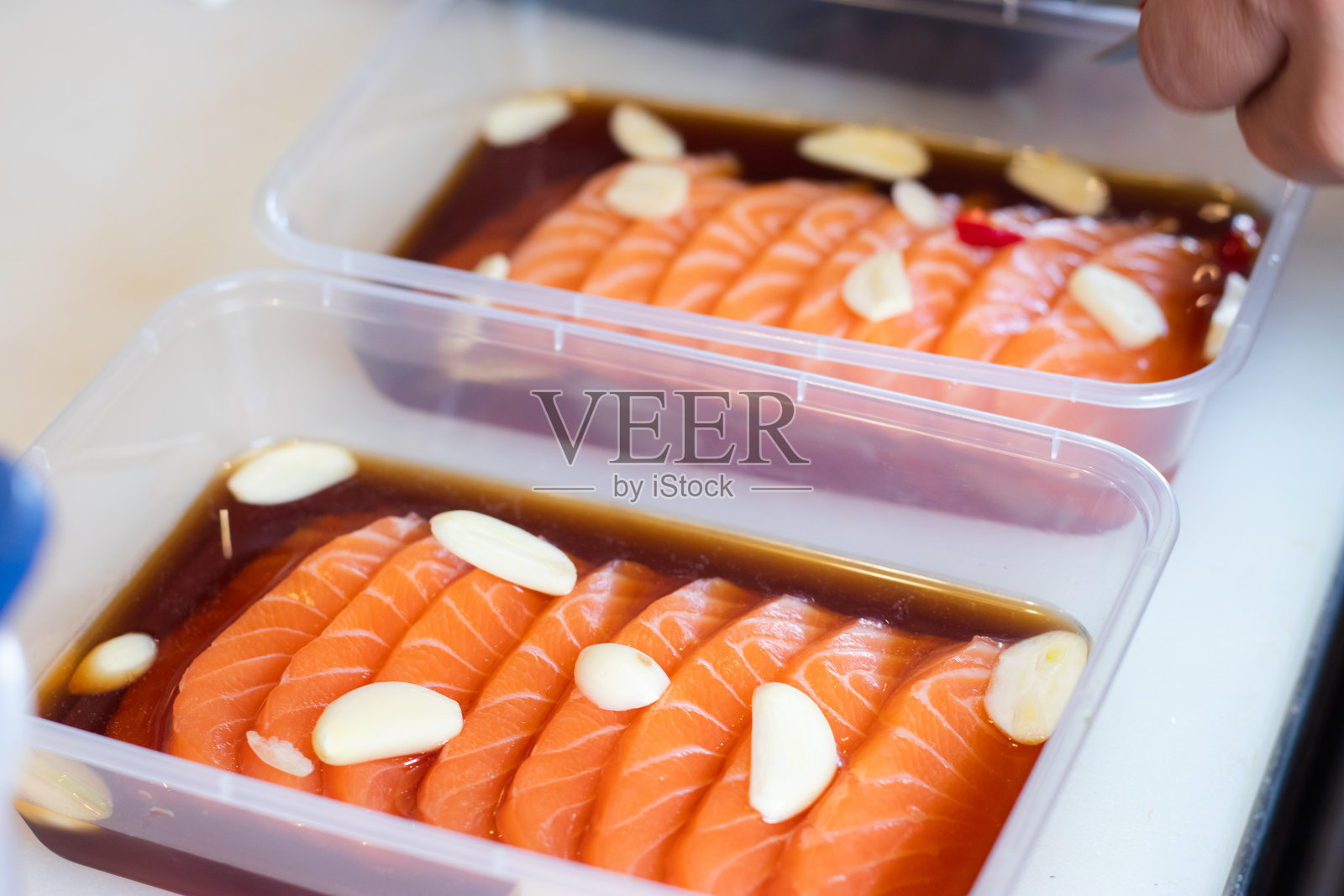 新鲜三文鱼配日本酱油，腌制在盒子里，是日本和韩国美食的结合。照片摄影图片