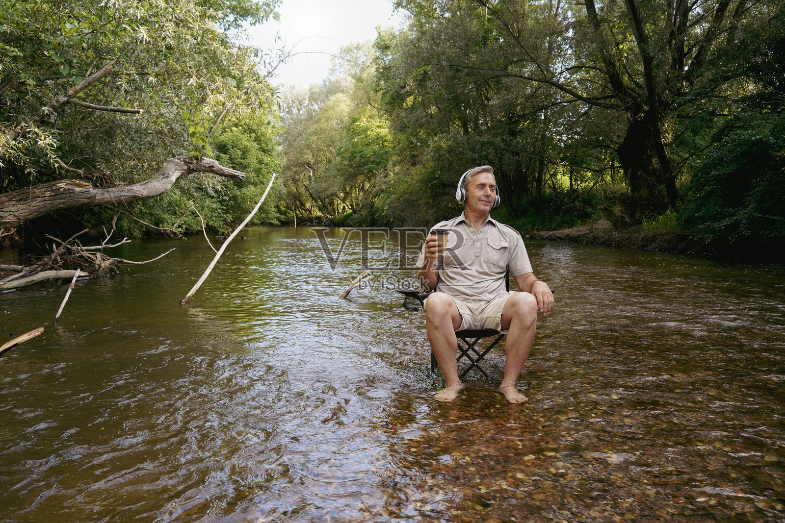 成熟男人在河边享受音乐和大自然照片摄影图片
