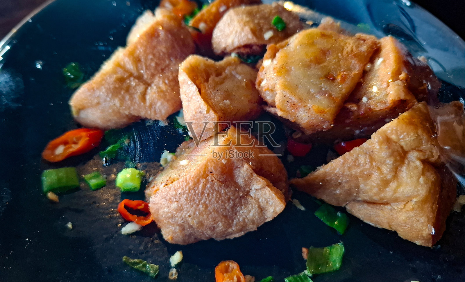 香脆金黄的炸豆腐，配以新鲜辣椒和葱花装饰照片摄影图片