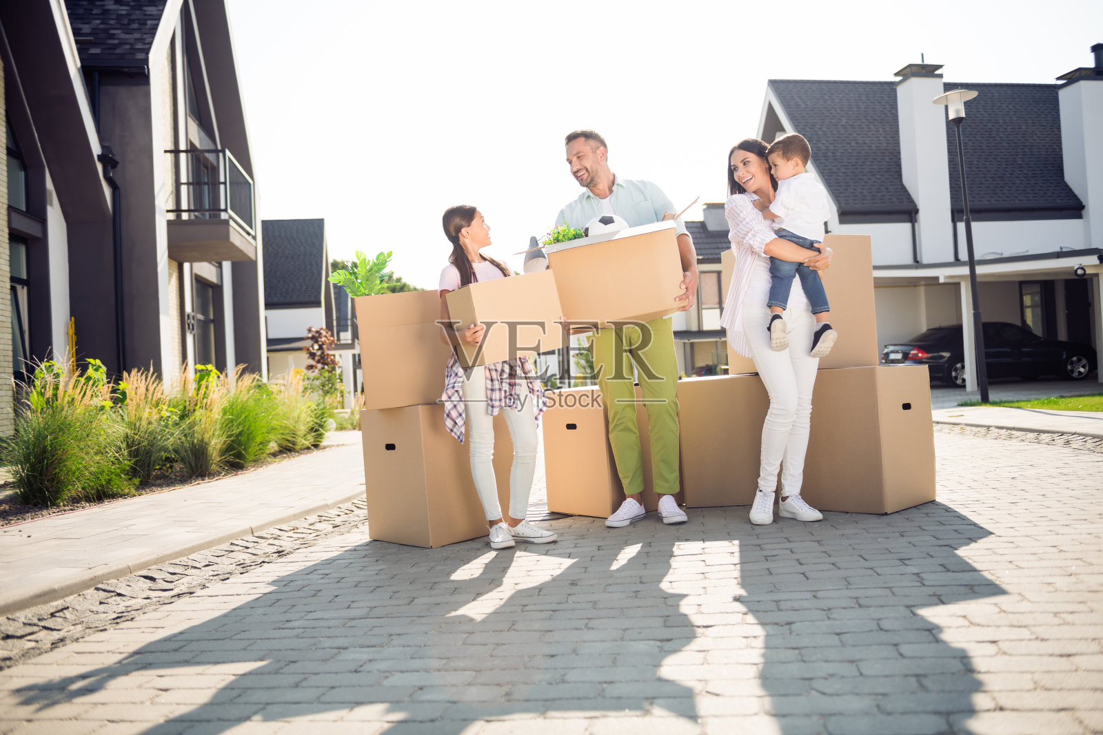 四个可爱快乐的小孩在乡村小屋外搬家，展现全身的身影。照片摄影图片