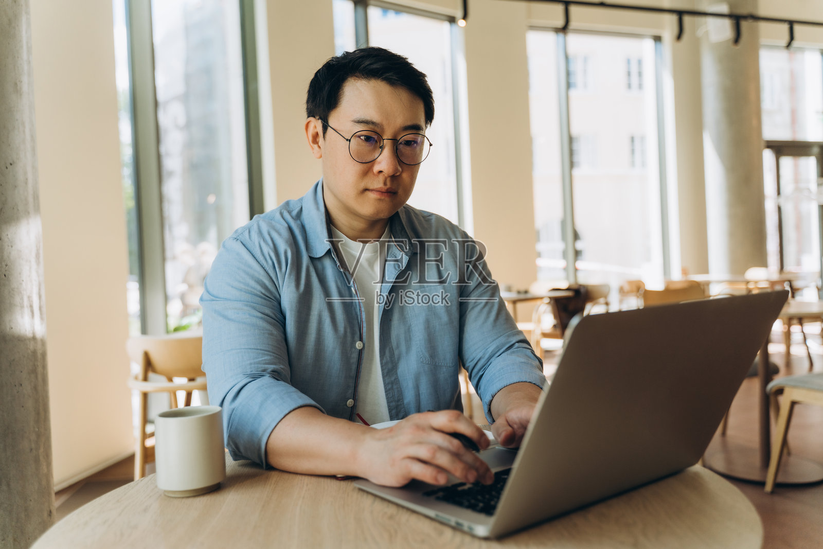 亚洲自由职业者在现代咖啡馆使用笔记本电脑工作照片摄影图片