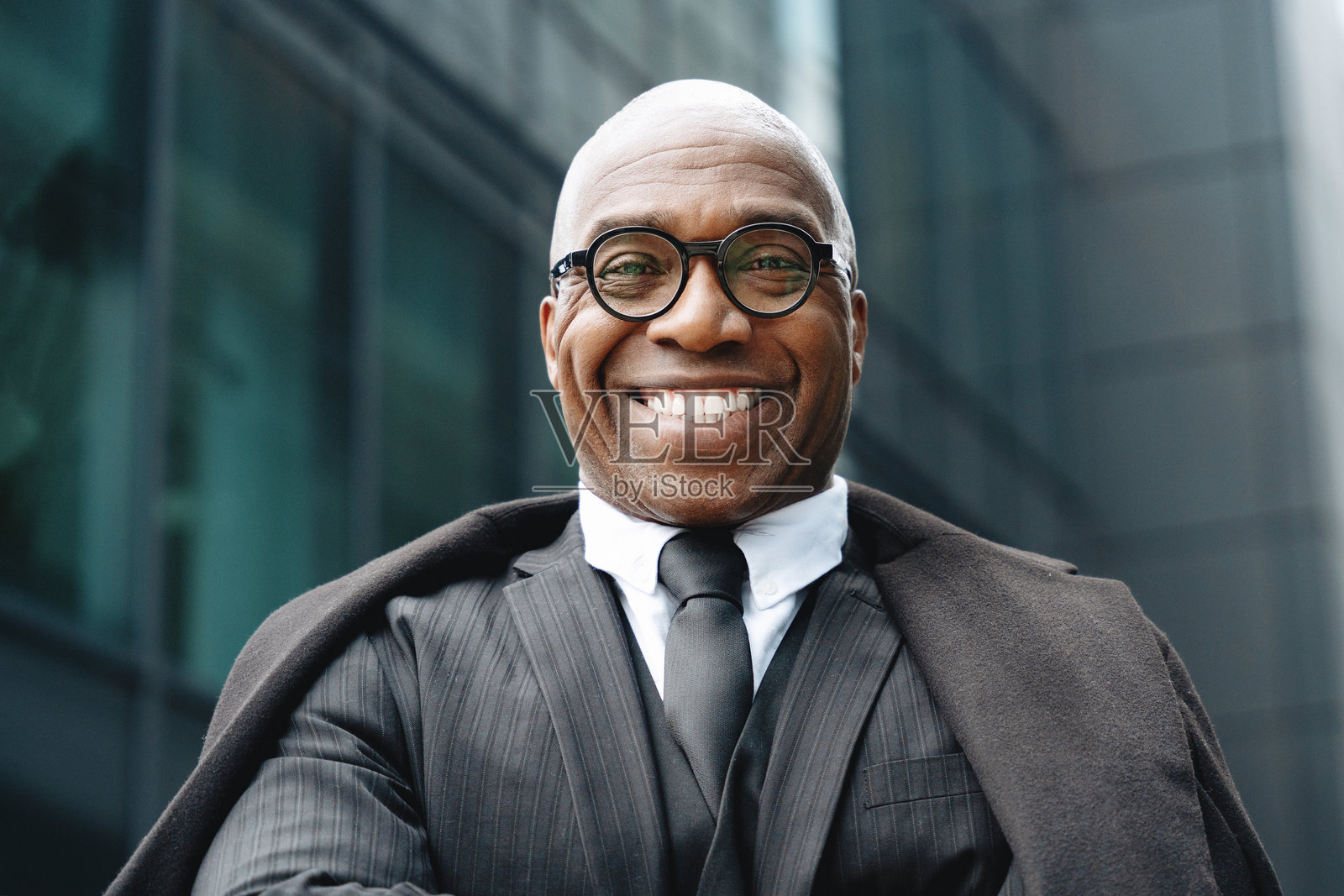 商务专业人士在现代城市环境中自信微笑，散发出魅力和亲和力。照片摄影图片