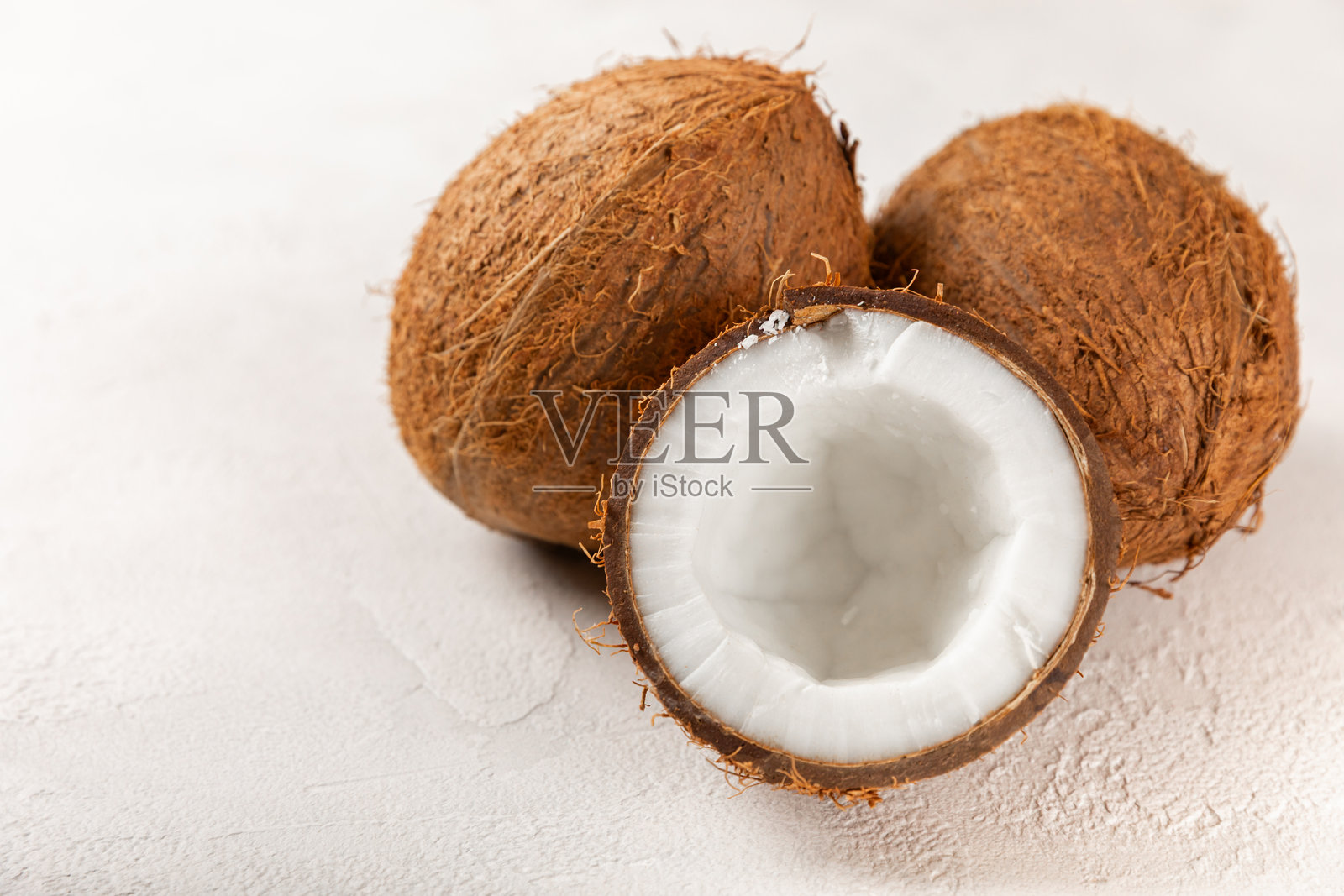 新鲜的整椰子和半个椰子以及切片，放在木质背景上。椰子片。素食。热带坚果，水果。留白处可添加文字。照片摄影图片