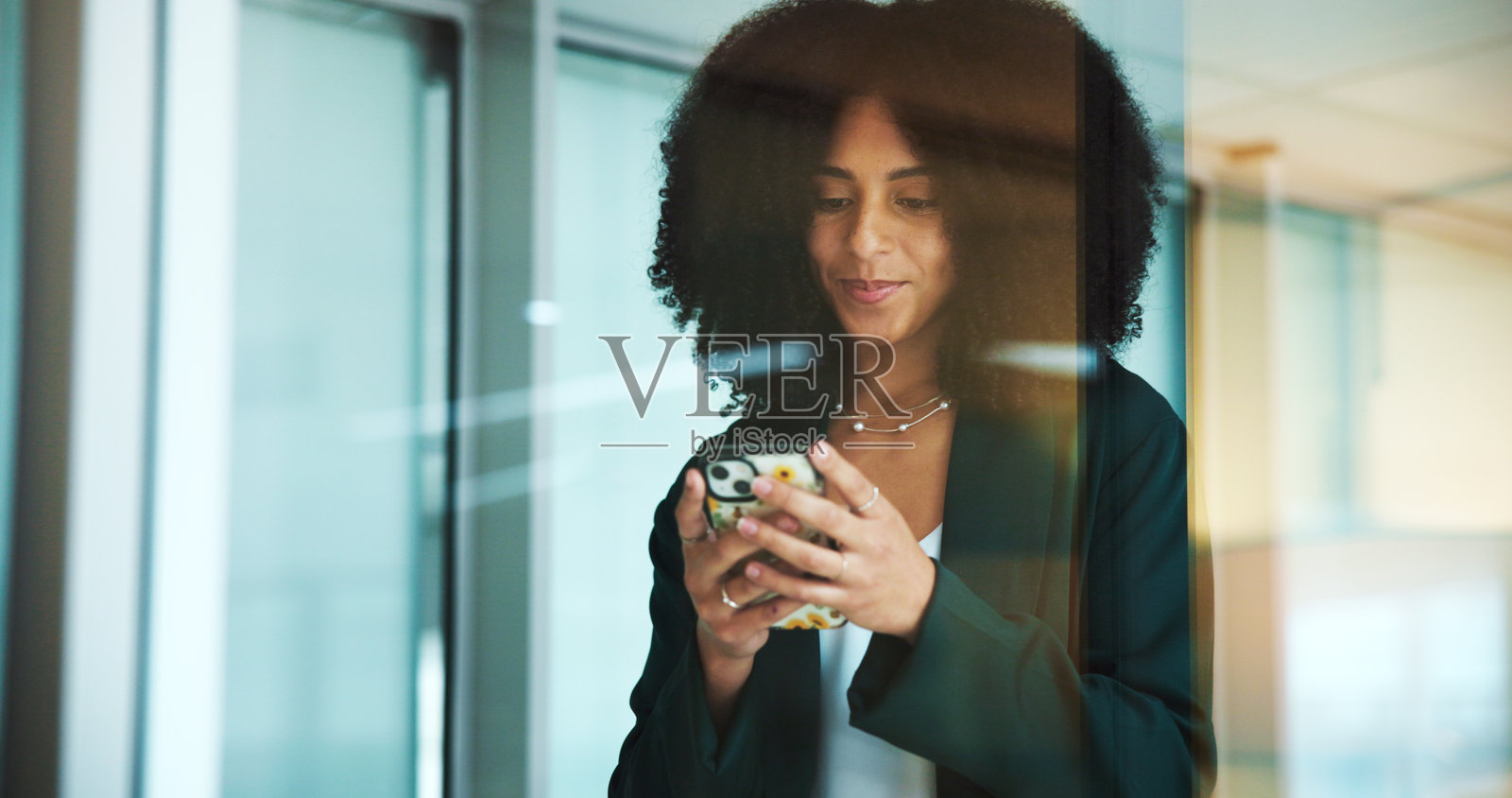 商务女性在办公室微笑着打电话和输入信息，适合用于沟通、网络或社交媒体发布。顾问、窗户和员工进行对话、发短信或发送电子邮件以进行项目管理。照片摄影图片