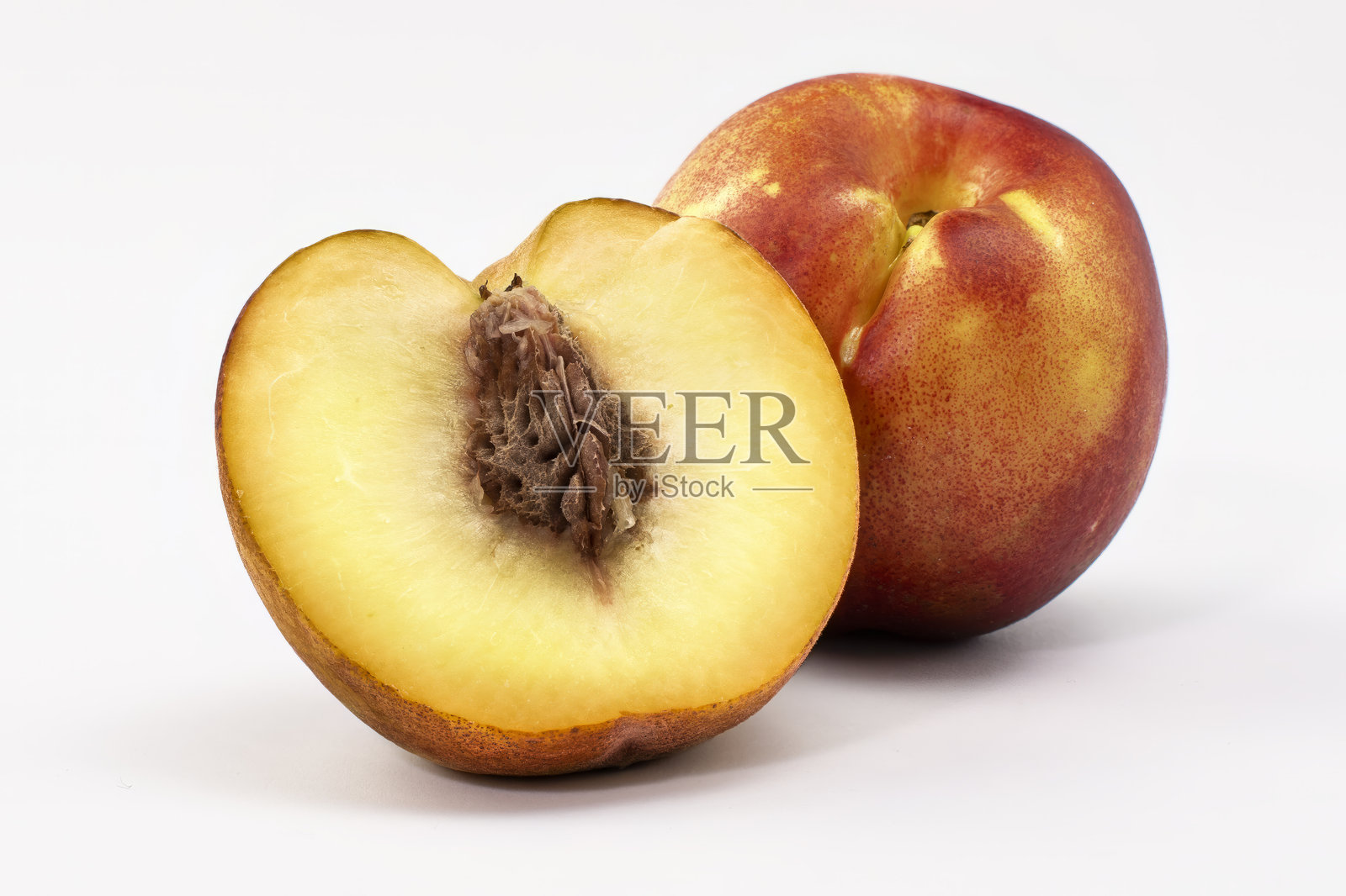 桃子，其中一个被切开。照片摄影图片