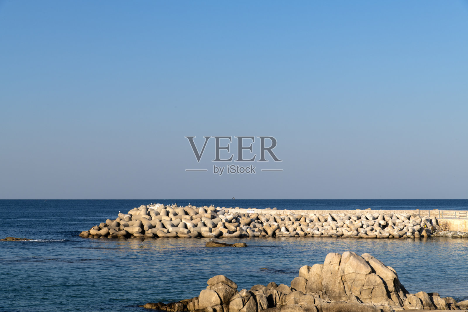 海边的岩石和码头照片摄影图片