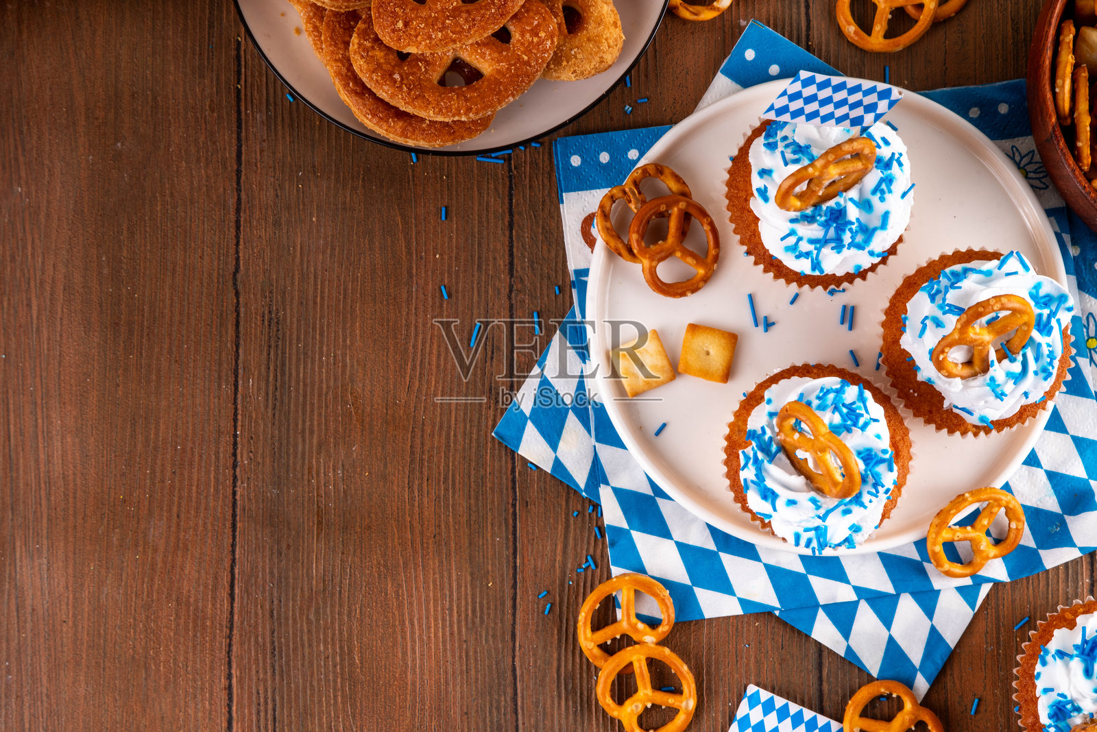 十月节杯子蛋糕，上面装饰着椒盐卷饼和五彩糖屑照片摄影图片