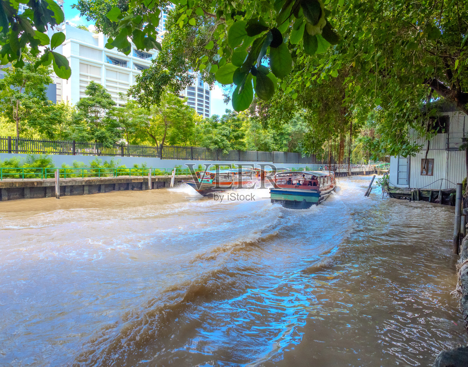 一艘渡船在泰国曼谷的运河（Khlong）上行驶，从暹罗到帕通湾。这是曼谷因交通拥堵而受到青睐的交通方式。照片摄影图片