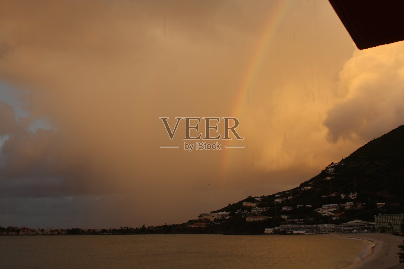 暴风雨过后日落时分的海湾彩虹照片摄影图片