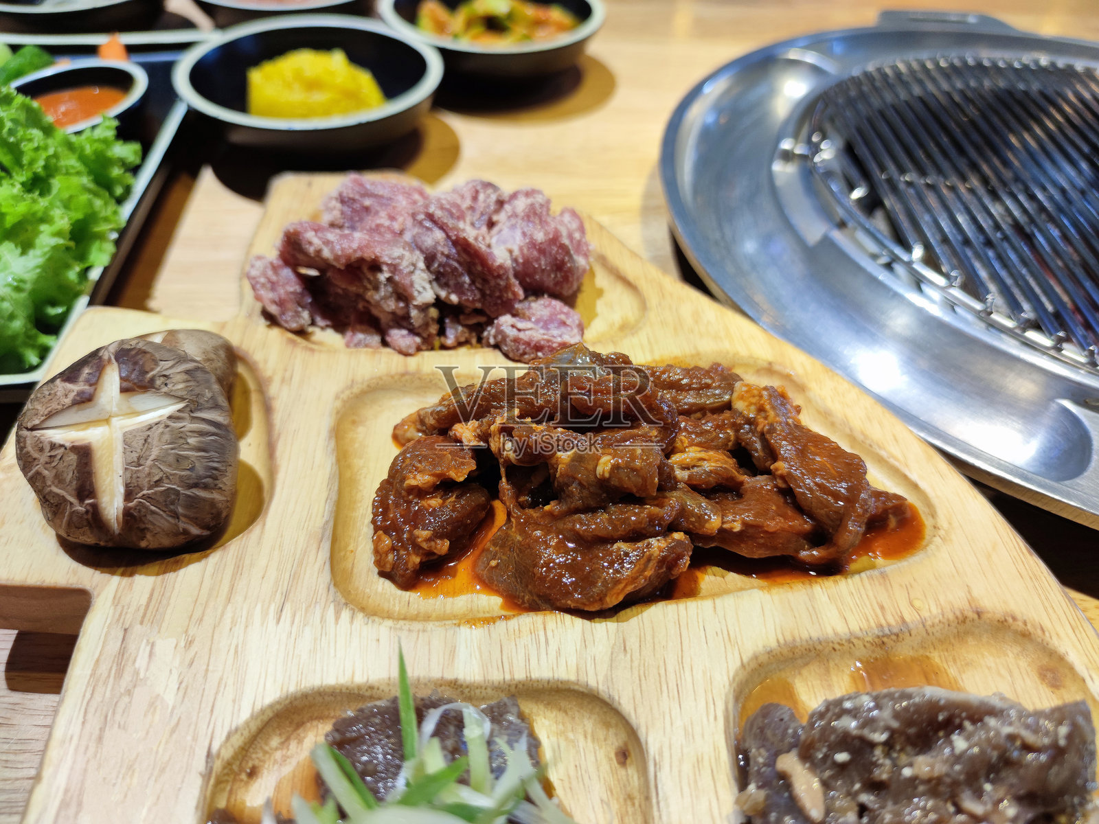 各种生肉在韩国烧烤桌上照片摄影图片
