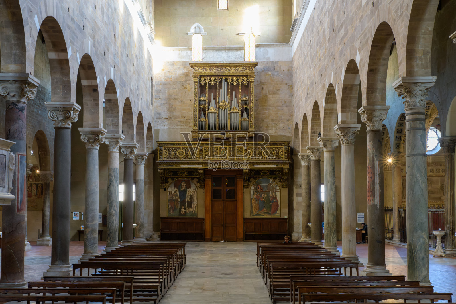 意大利卢卡的圣弗雷迪亚诺大教堂的罗曼式中殿，配有管风琴、彩绘合唱团楼、雕刻大理石柱和拱形柱廊。照片摄影图片