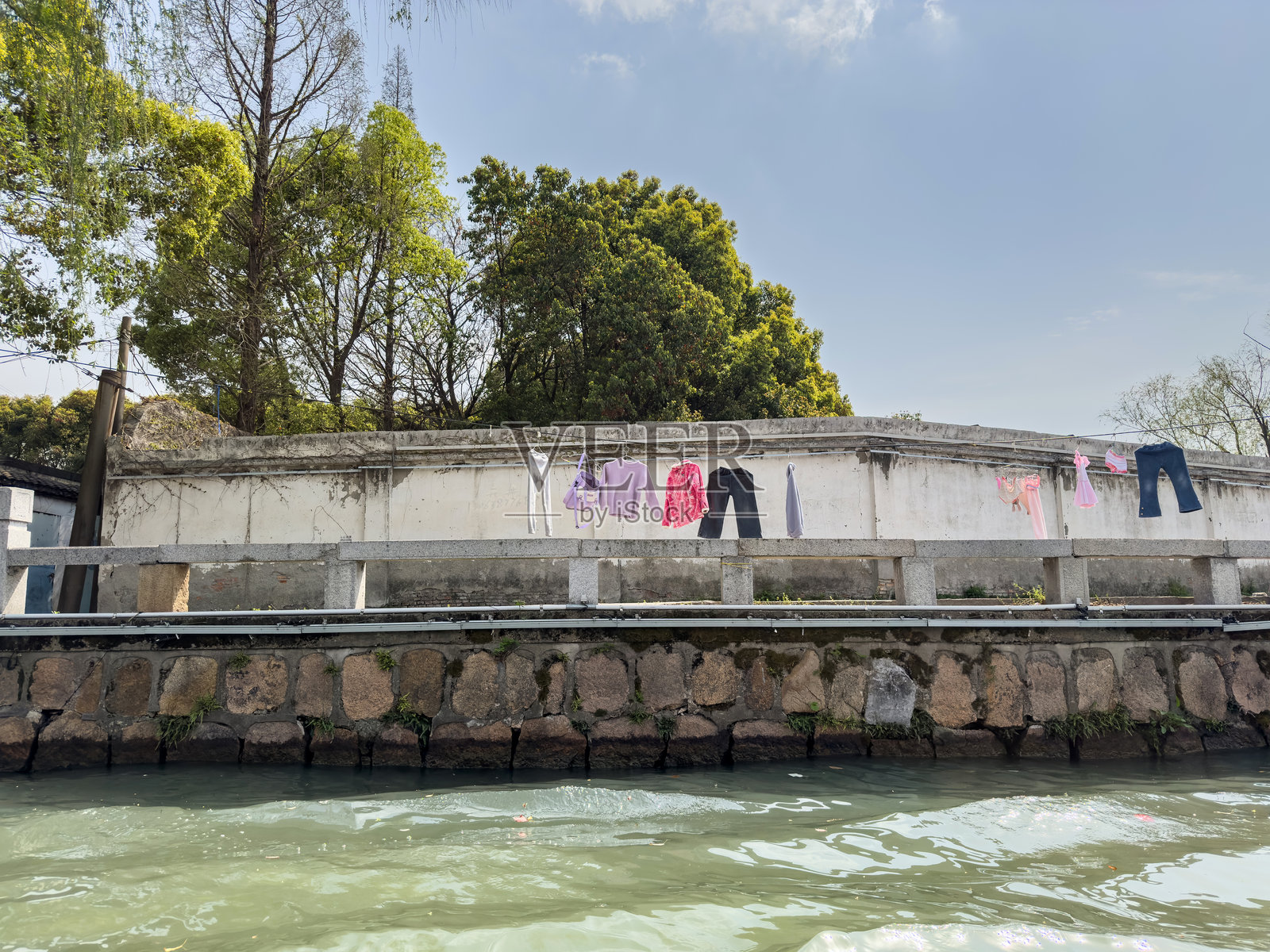 衣服在中国传统水乡的河道上晾干。苏州，中国。照片摄影图片