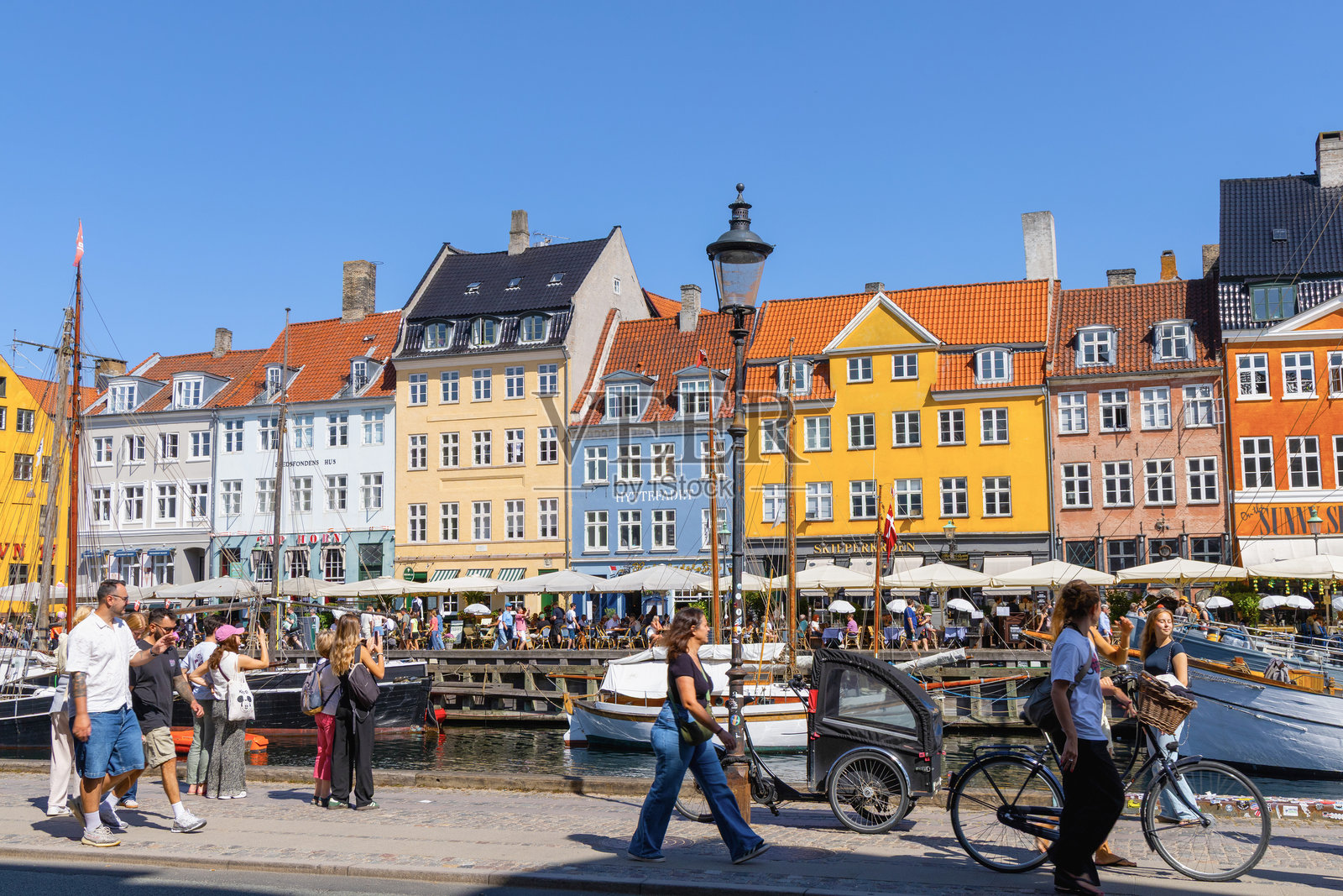 色彩斑斓的尼哈芬海滨，船只与生动的历史丹麦建筑。照片摄影图片