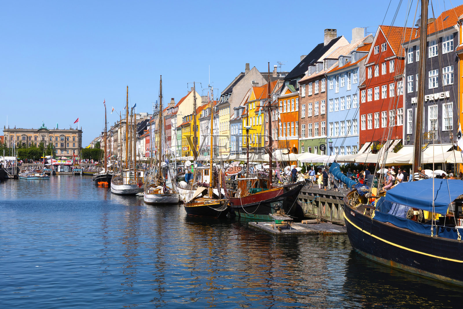 阳光明媚的尼哈芬港口，停着船只和色彩斑斓的丹麦历史建筑。照片摄影图片