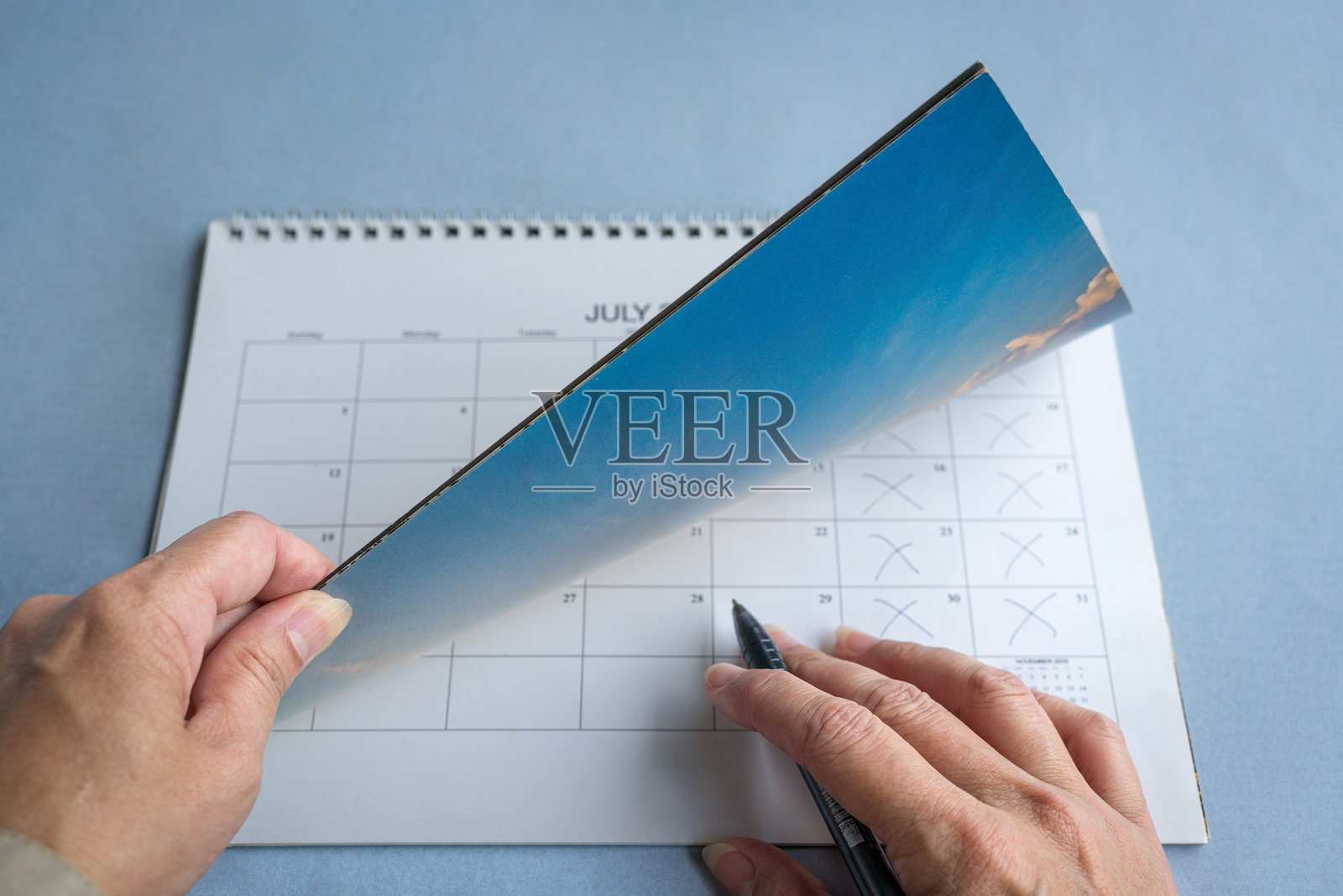 女人的手在翻阅日历。照片摄影图片