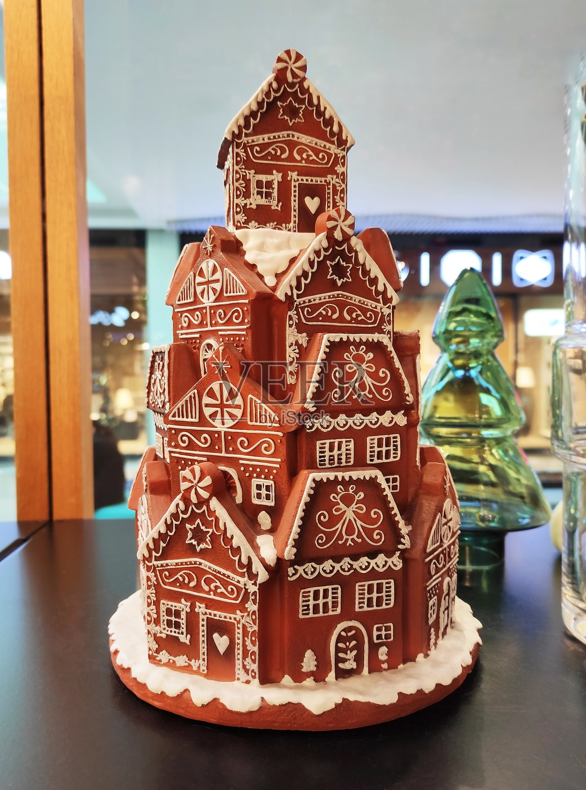姜饼屋上覆盖着白色糖霜，装饰有雪花、漩涡和饰品的图案。节日的室内装饰，温暖的圣诞氛围。照片摄影图片
