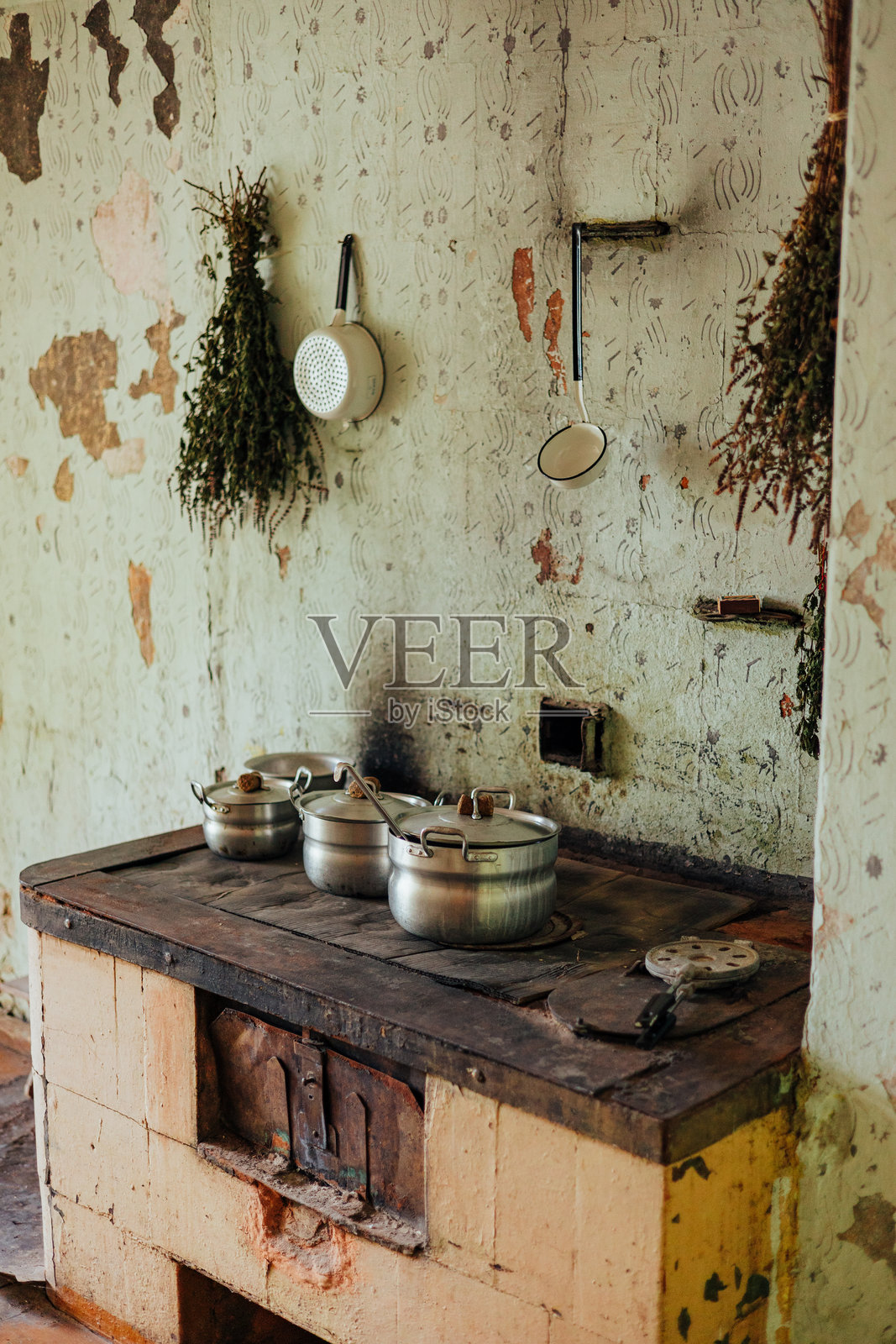 乡村厨房，配有旧炉灶和悬挂的香草照片摄影图片