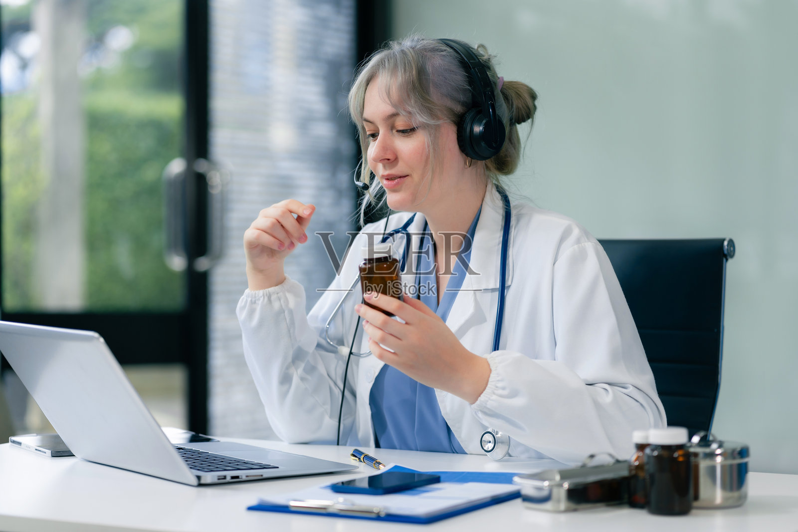 关心的治疗师进行视频咨询，通过在线会议与患者沟通，使用笔记本电脑，进行诊断，推荐并开处方药物，同时回答问题。照片摄影图片