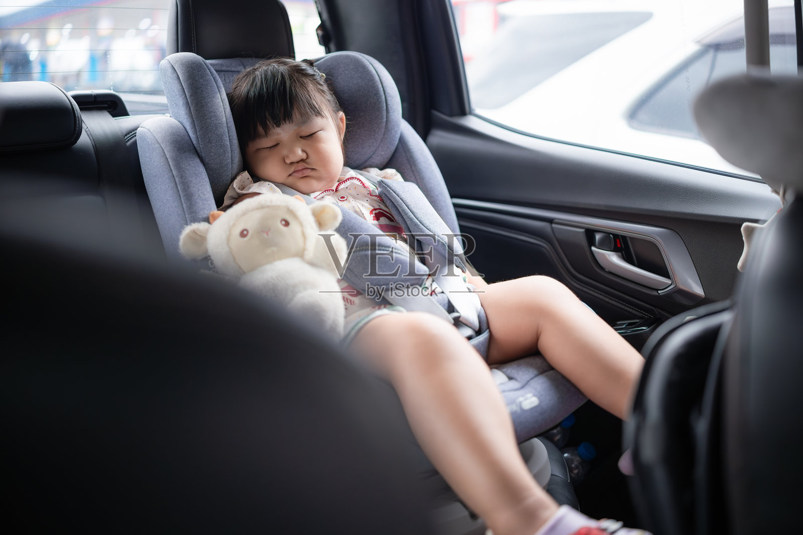 一个小女孩在汽车座椅上睡觉。照片摄影图片
