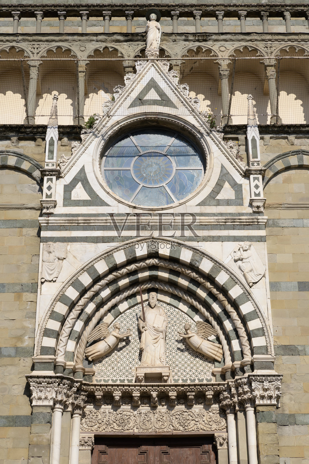 意大利皮斯托亚圣保罗教堂门口的细节，雕塑为雅各布·迪·马泽奥创作的圣保罗，创作于1302年。照片摄影图片