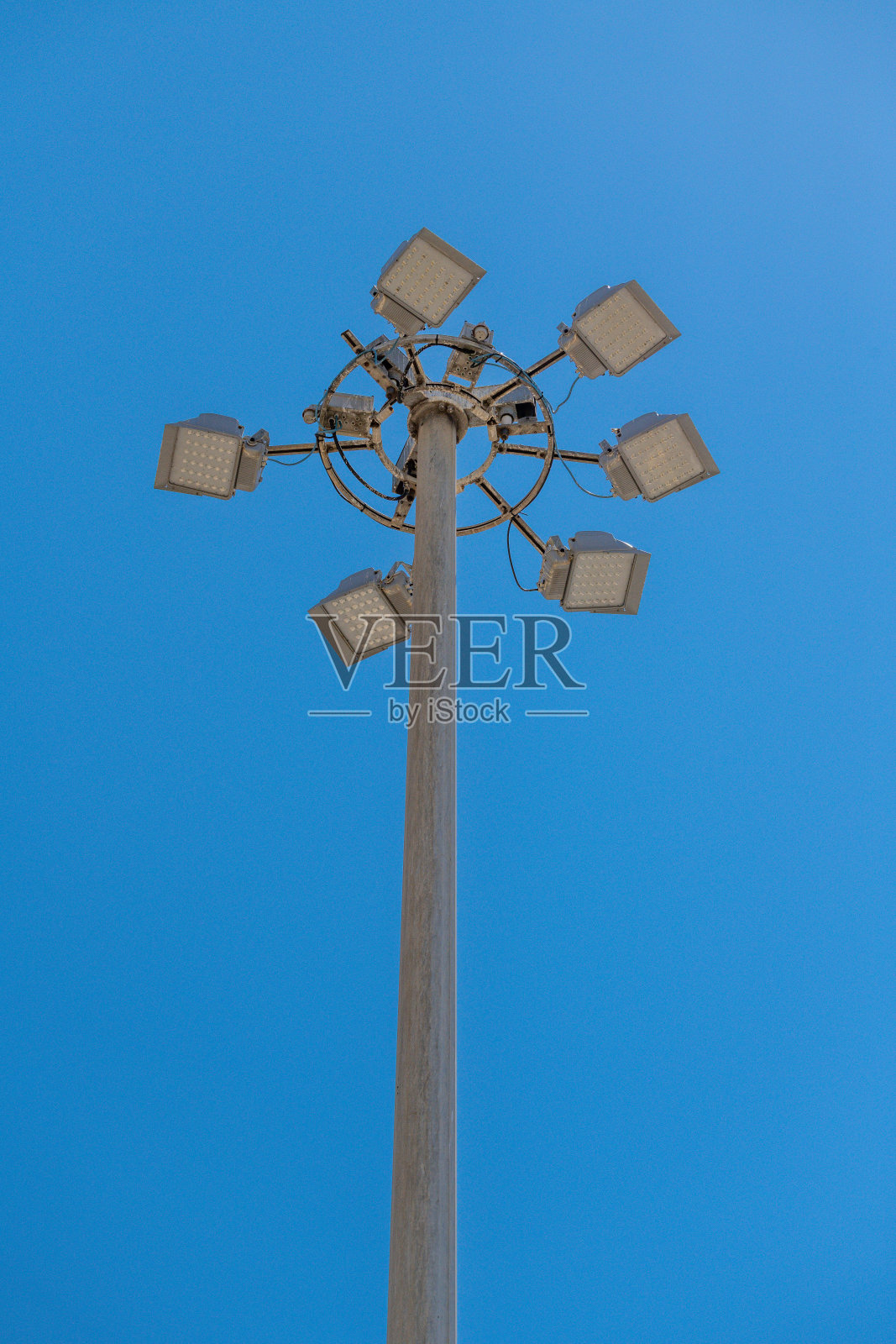 高大的金属杆上装有圆形LED泛光灯照片摄影图片