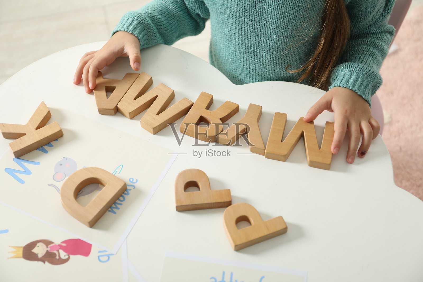 小女孩在室内白色桌子上用木制字母学习字母表，特写镜头照片摄影图片