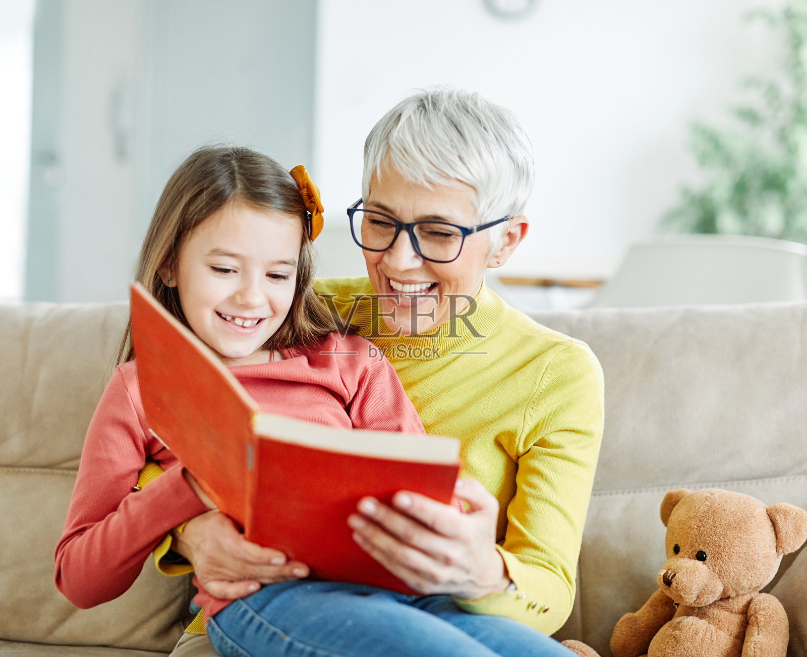 孙女与祖母快乐地一起阅读书籍，享受学习的时光。照片摄影图片