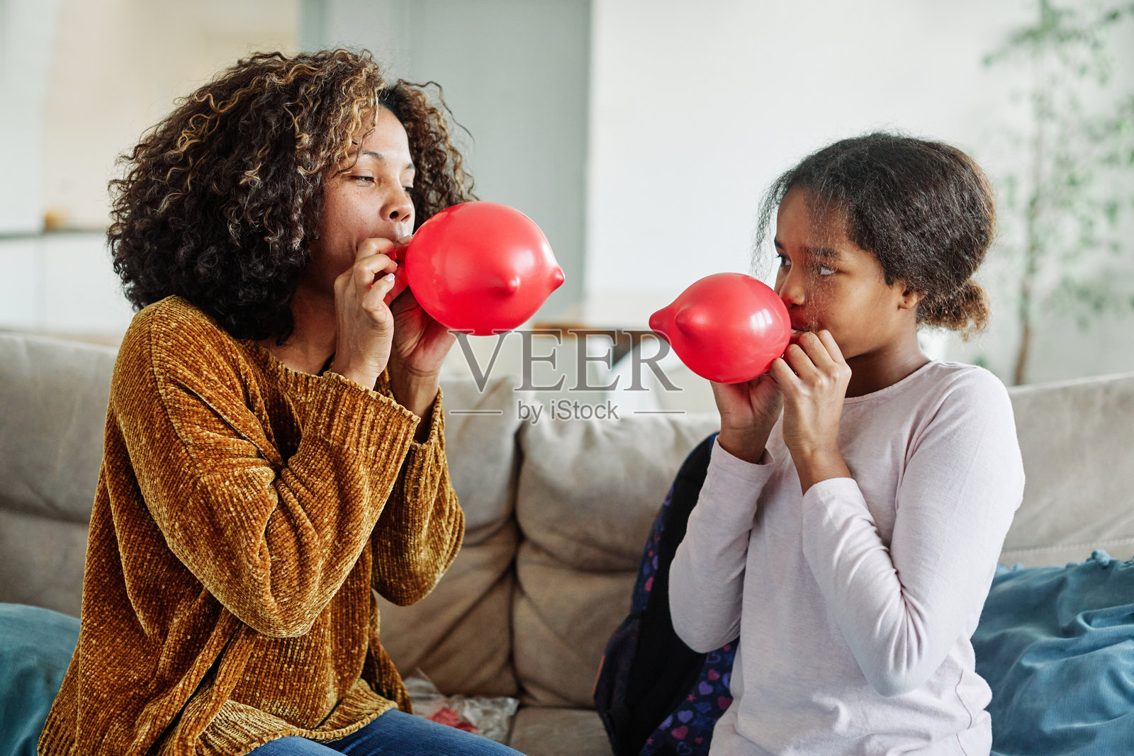 快乐的母女家庭在派对上玩气球，庆祝生日，享受童年时光。照片摄影图片