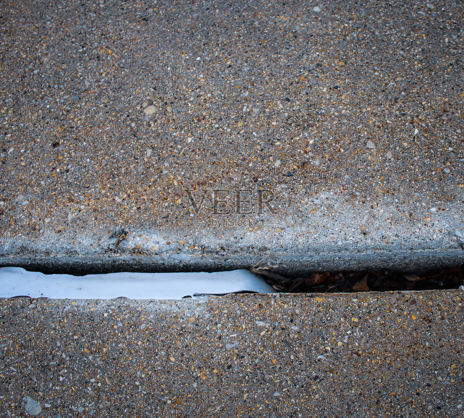 一条密封胶条掉入混凝土板之间的伸缩缝或缝隙中照片摄影图片