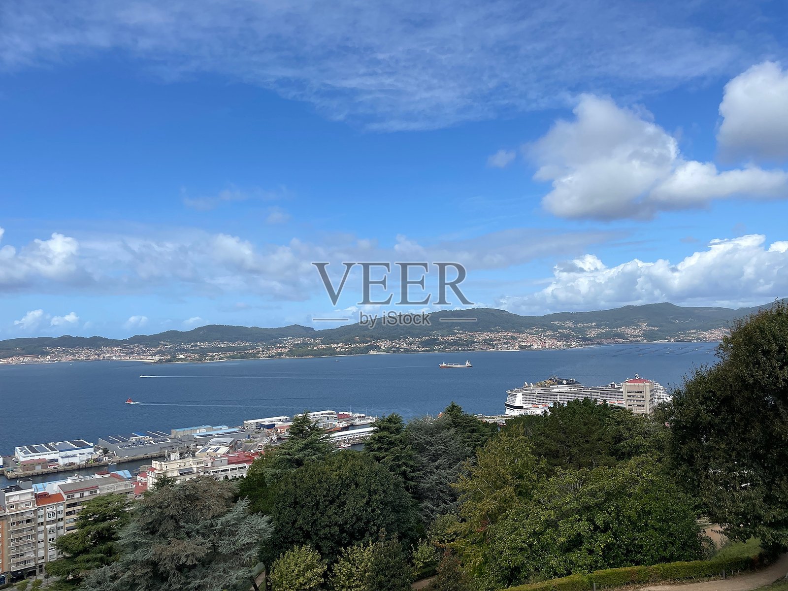 风景如画的海滨城市和港口，蓝天下停靠着游轮。照片摄影图片