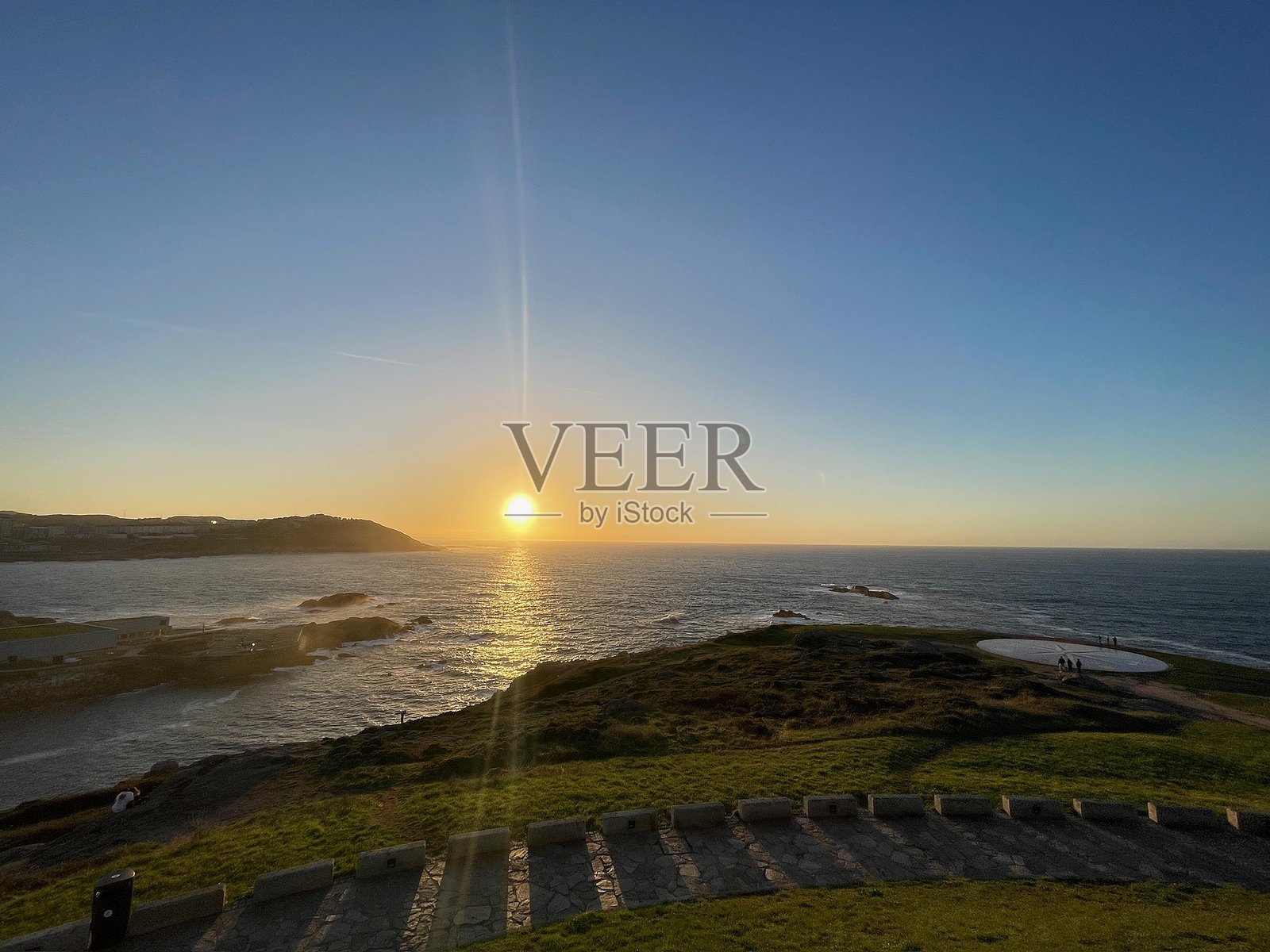 壮观的金色日落映照在海岸风景和海洋上。照片摄影图片