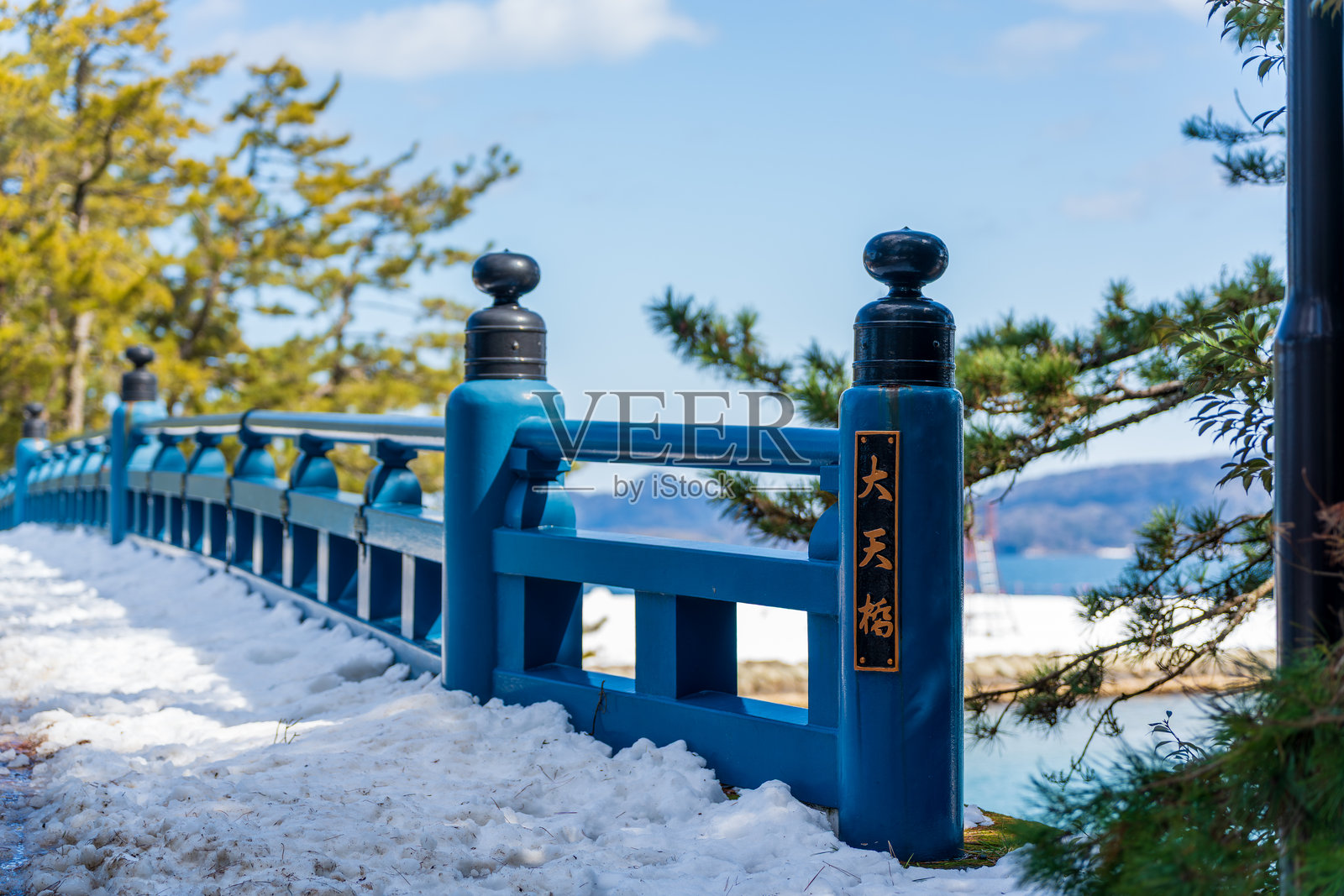 雪覆盖的天桥大天桥蓝色栏杆,位于京都宫津的天桥沙洲小径上。照片摄影图片