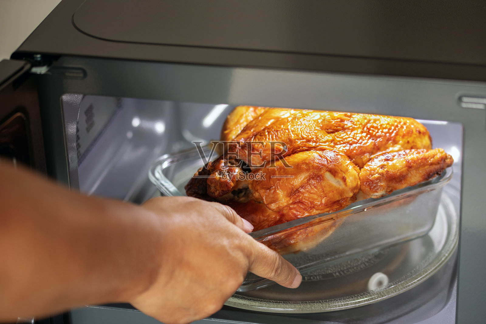 Heating food in the microwave. Chicken grill. Kitchen device照片摄影图片