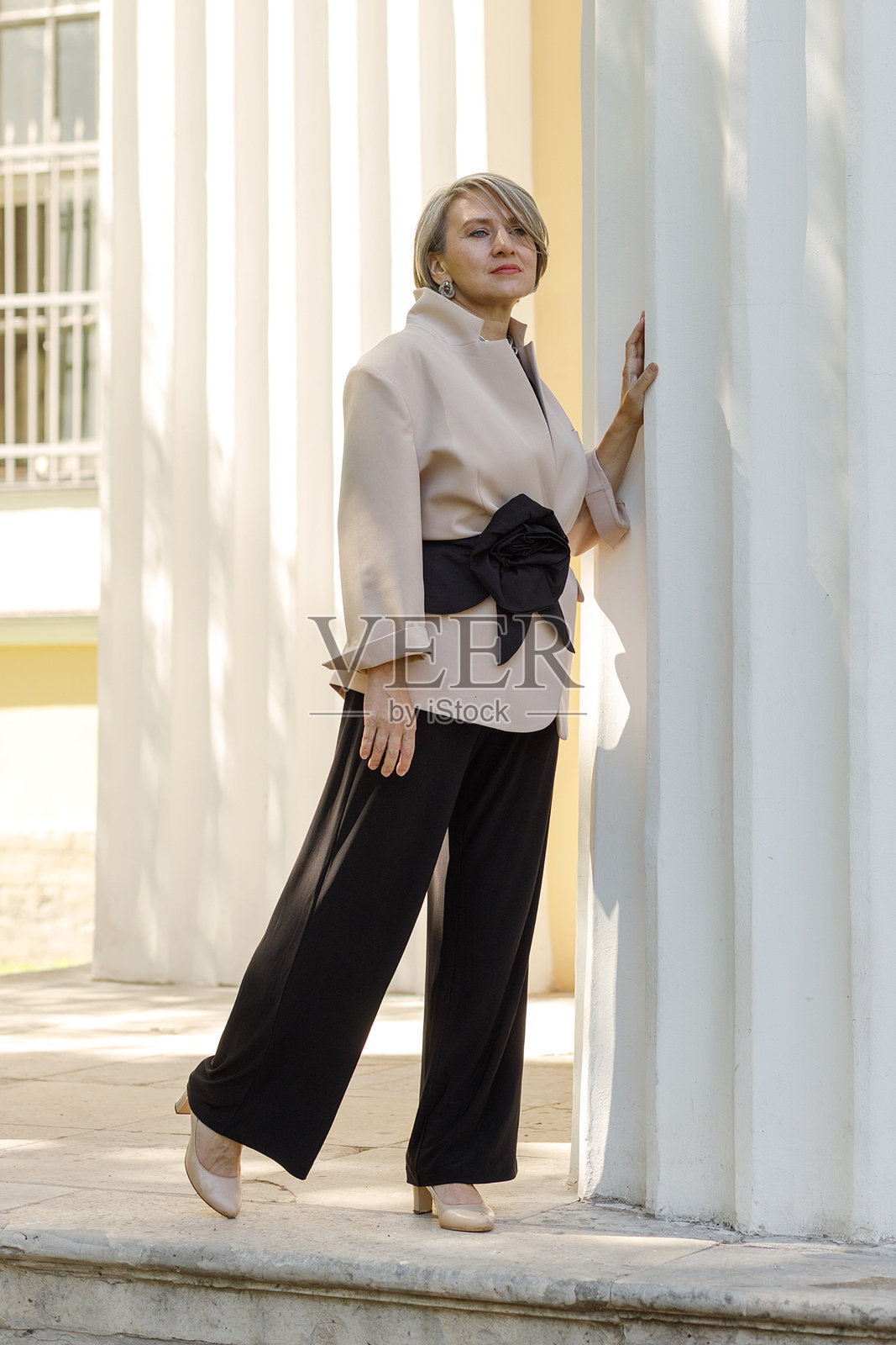 穿着优雅服装的快乐商务女性在公园里摆姿势。照片摄影图片