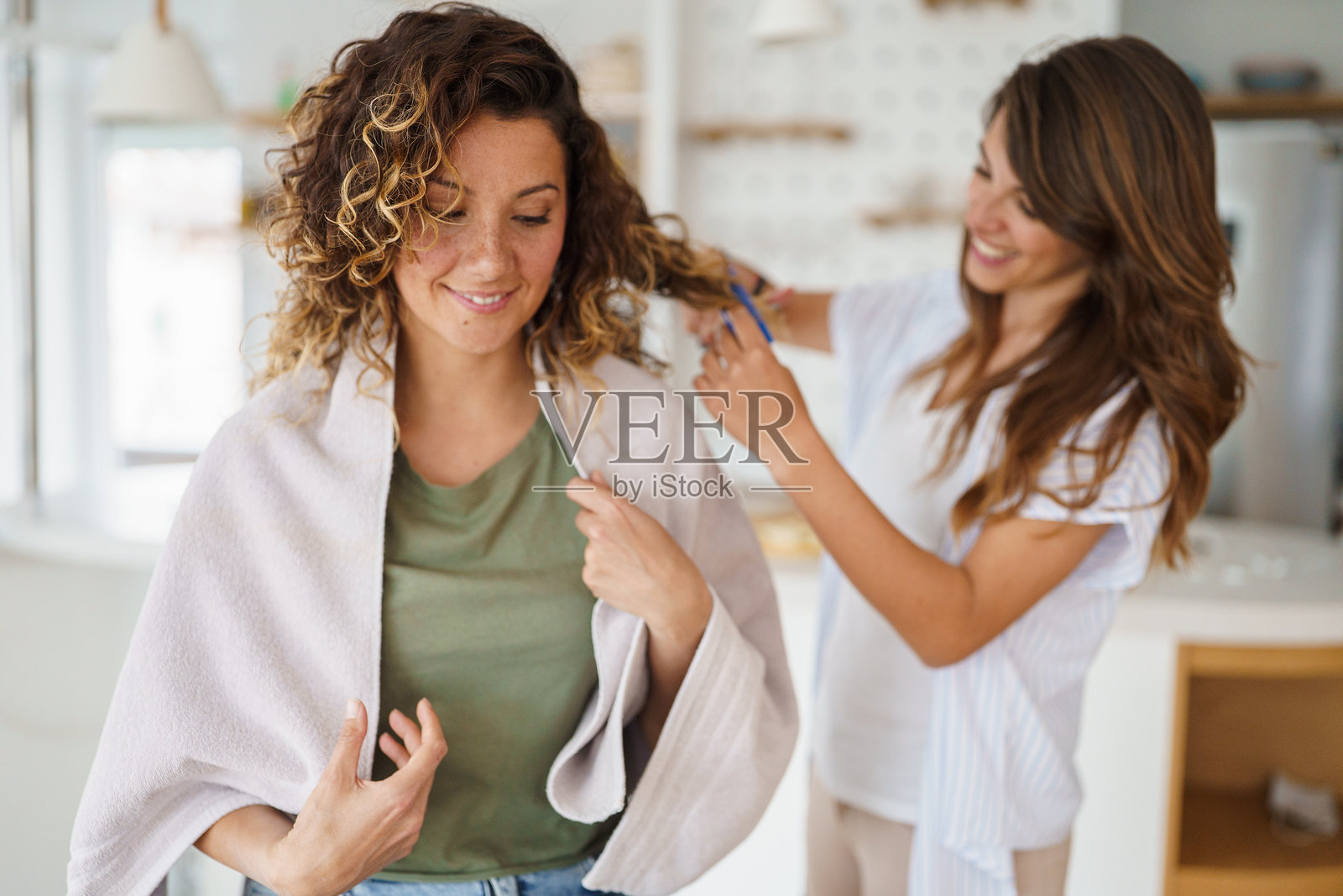 微笑的朋友们在明亮舒适的家居环境中享受有趣的理发时光照片摄影图片