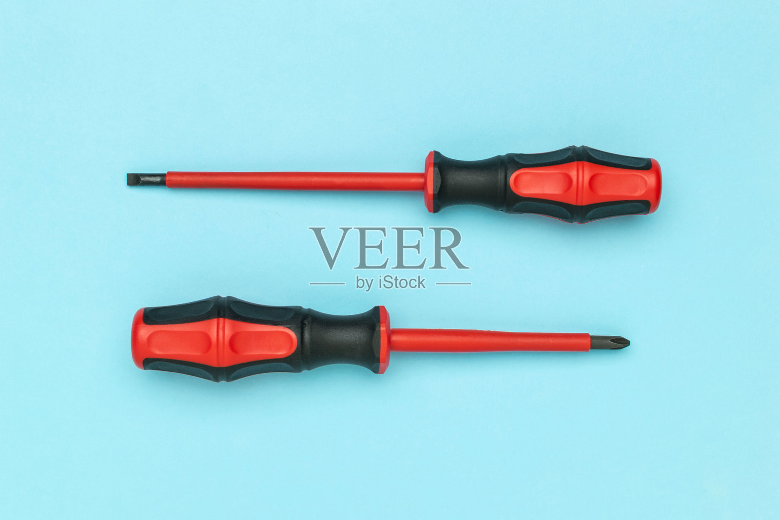 红色和黑色螺丝刀的顶部和侧面视图，背景为蓝色照片摄影图片