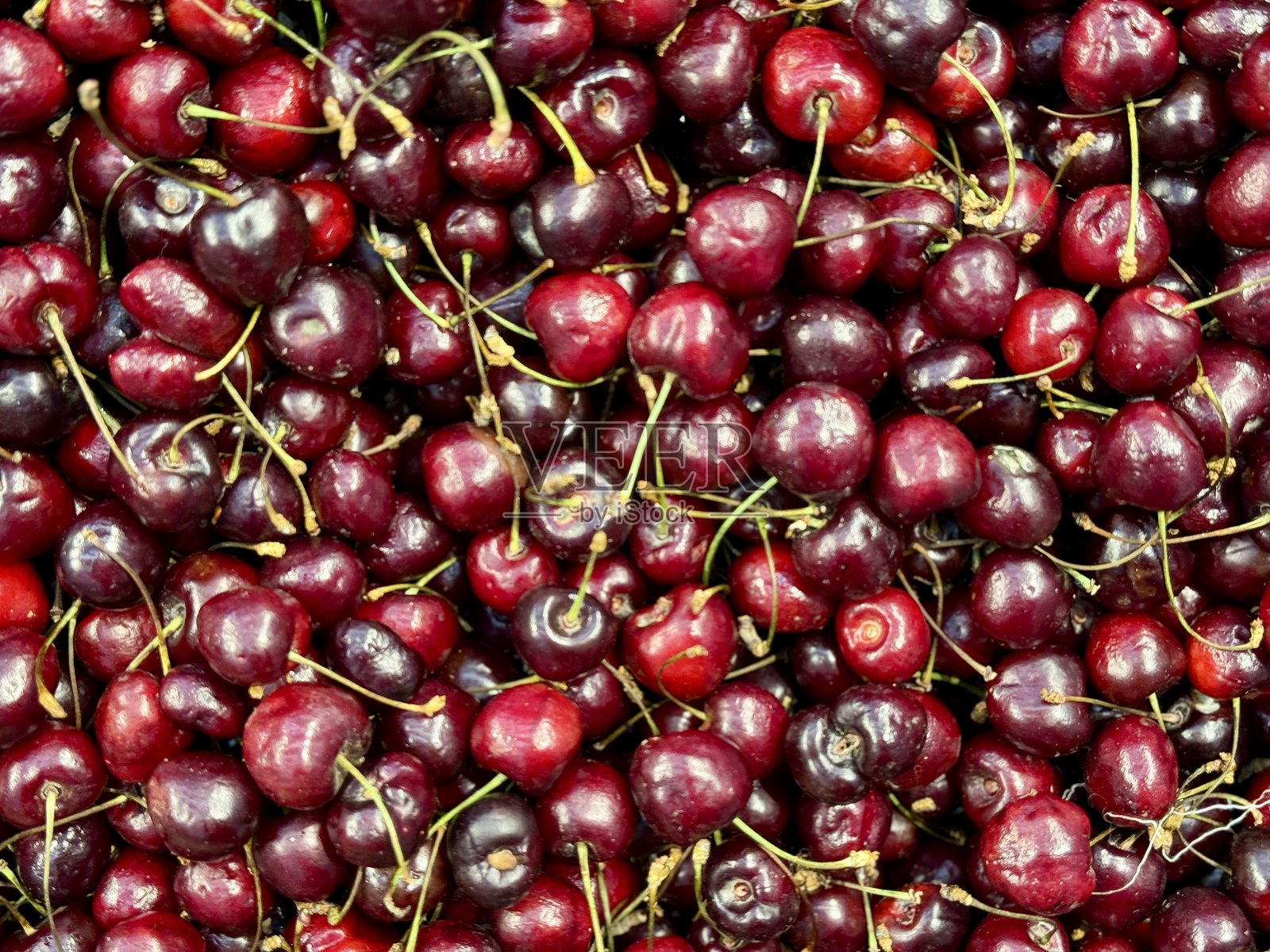 红色成熟的樱桃，广泛用于制作美味的季节性美食和风味。鲜艳的樱桃美丽地堆叠在一起，展现出它们诱人的多汁感。照片摄影图片