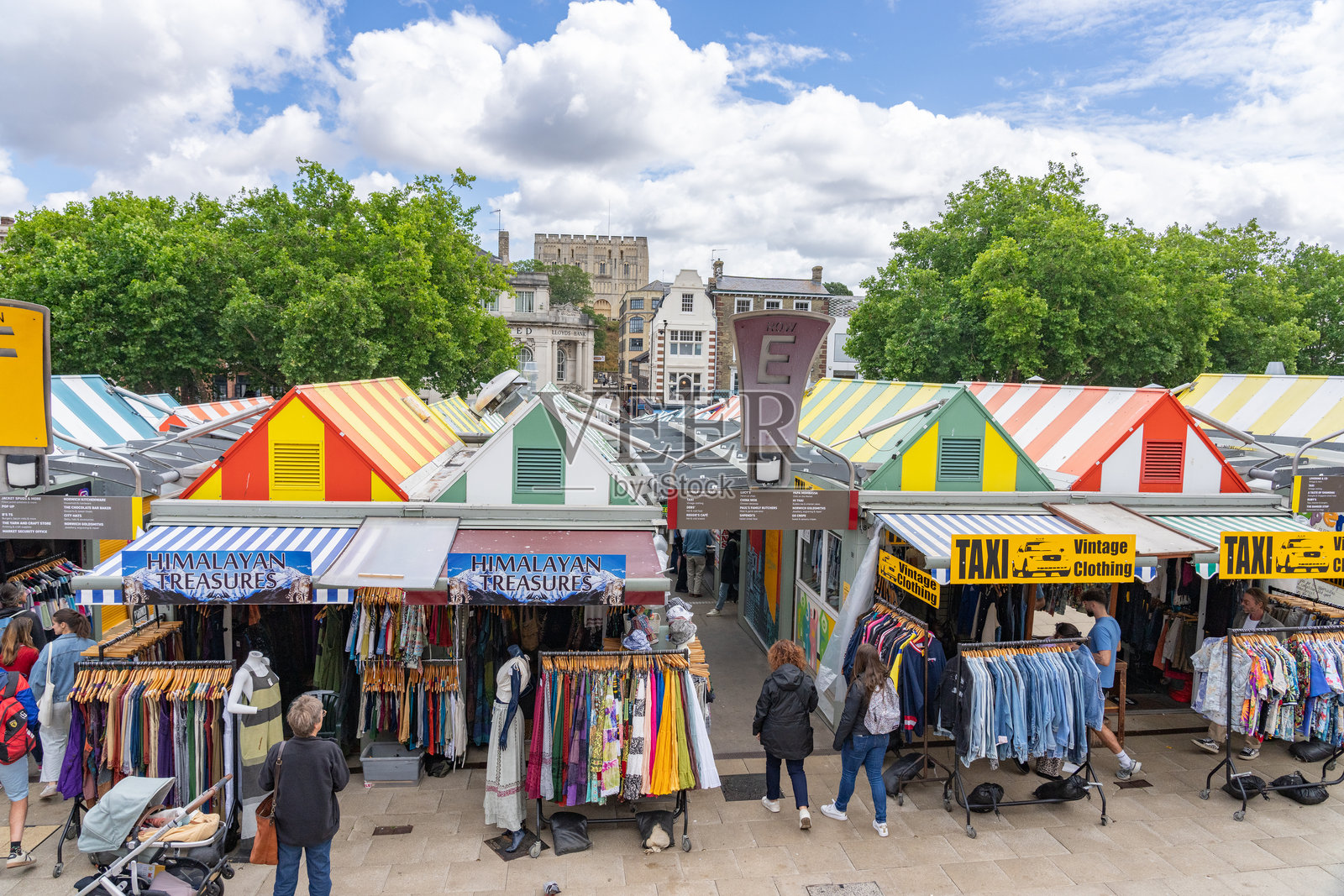 诺里奇市的市场,带有条纹的多彩屋顶和复古的氛围,还有人们。照片摄影图片