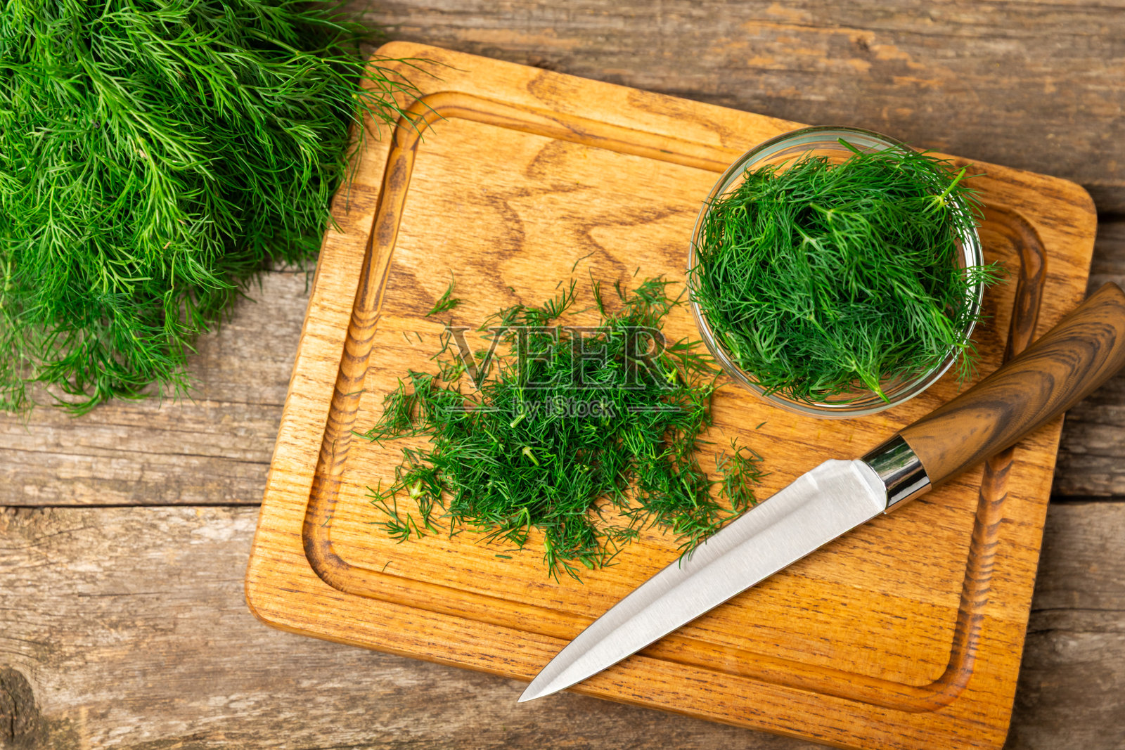 木质背景上的莳萝。新鲜有机绿叶。莳萝种植。切好的莳萝叶。春季嫩莳萝束。维生素。纤维。芳香的烹饪香料。留白区域。照片摄影图片